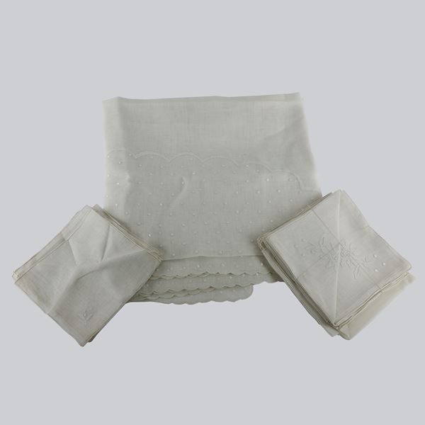 White linen tablecloth with floral embroidery and dots,