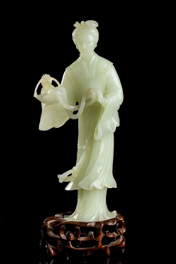 A PALE GREEN STONE SCULPTURE WITH A FEMALE FIGURE