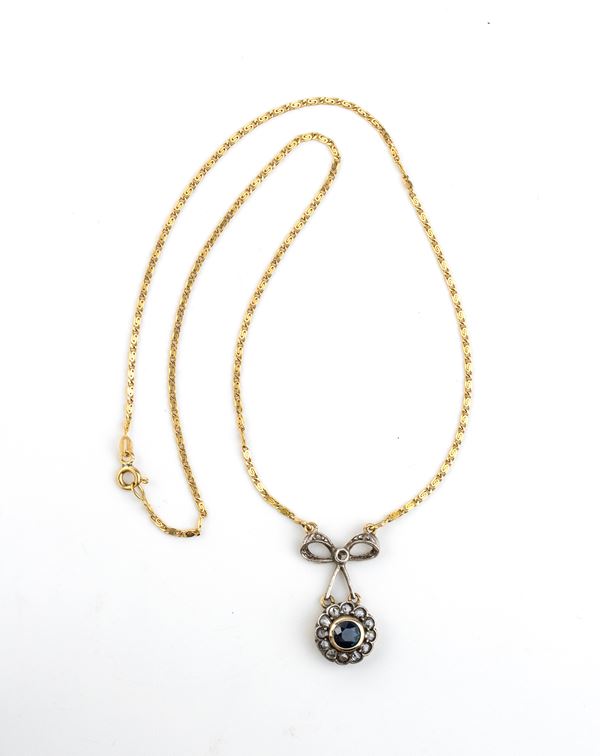 Gold necklace with gold and silver pendant with a sapphire and diamonds 