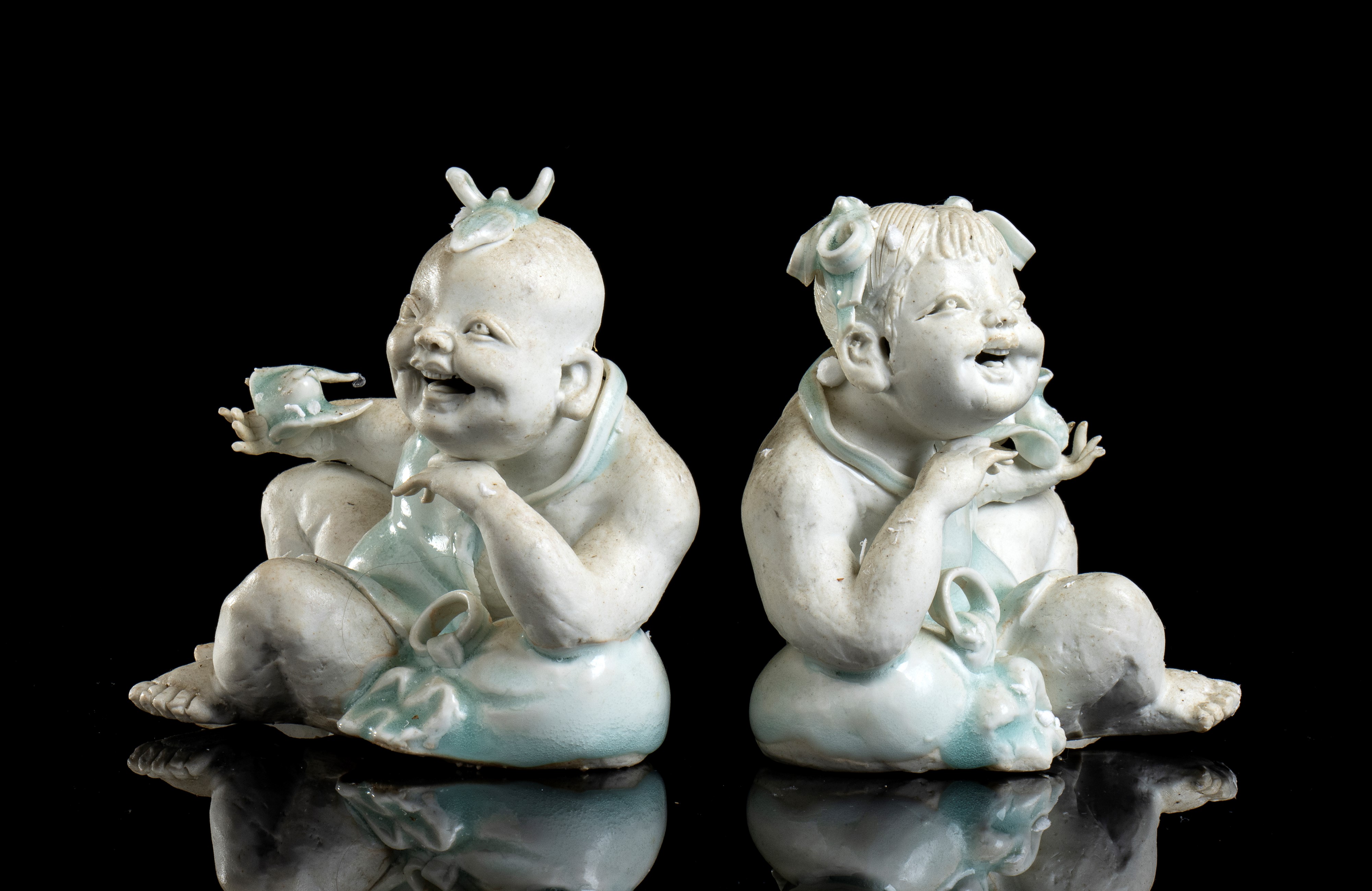 DUE FIGURE DI BAMBINI IN PORCELLANA BISCUIT E PARZIALMENTE INVETRIATA