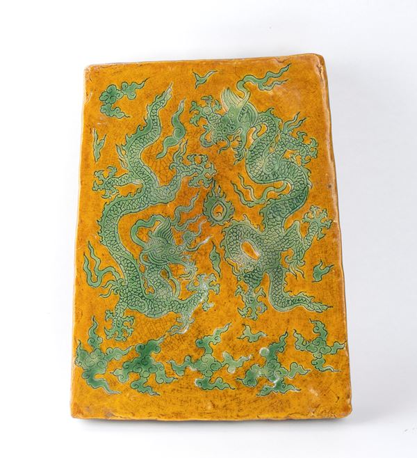 A GREEN AND YELLOW ENAMELLED CERAMIC TILE