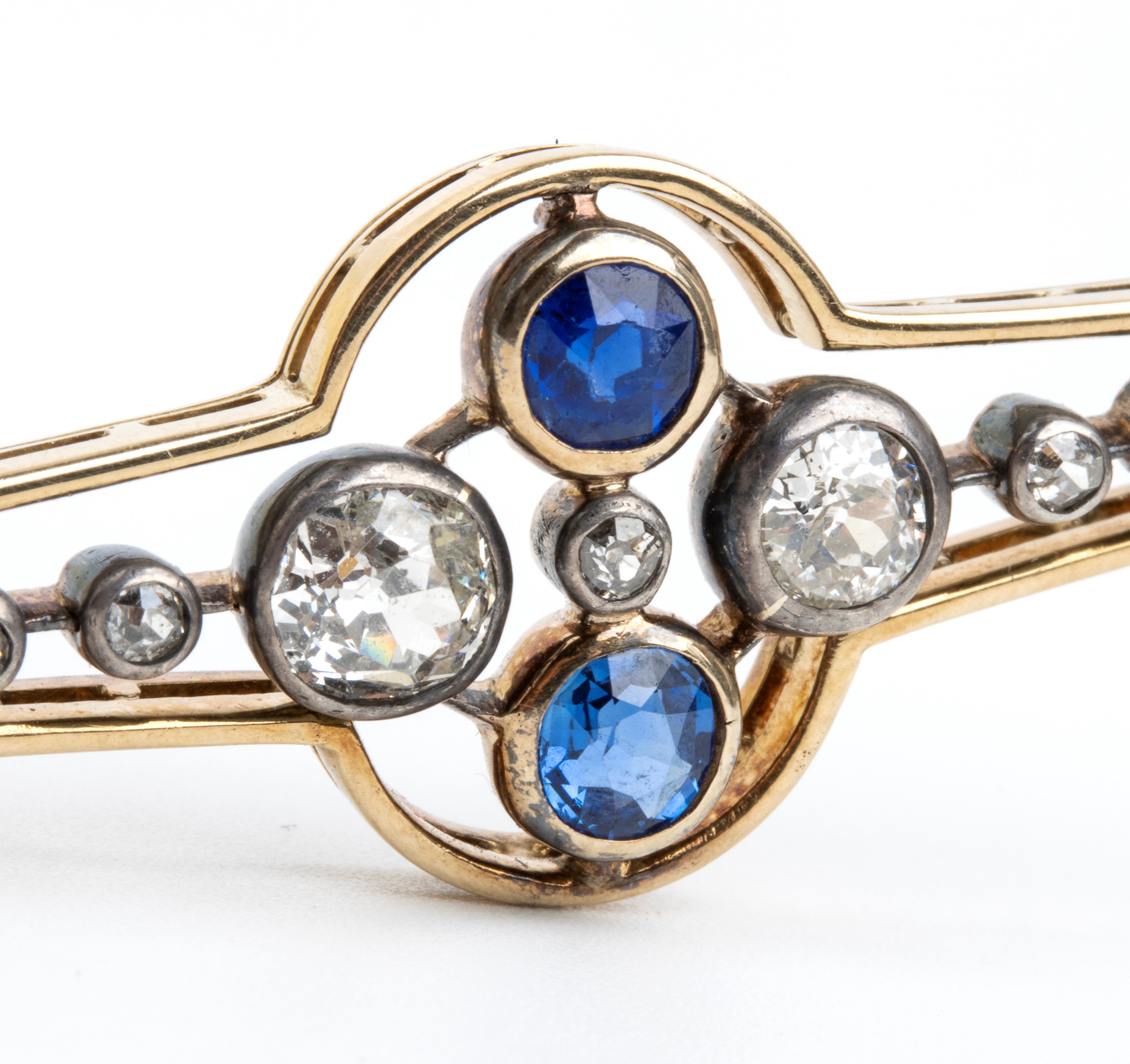 Spilla a barretta in oro, argento, diamanti e zaffiri