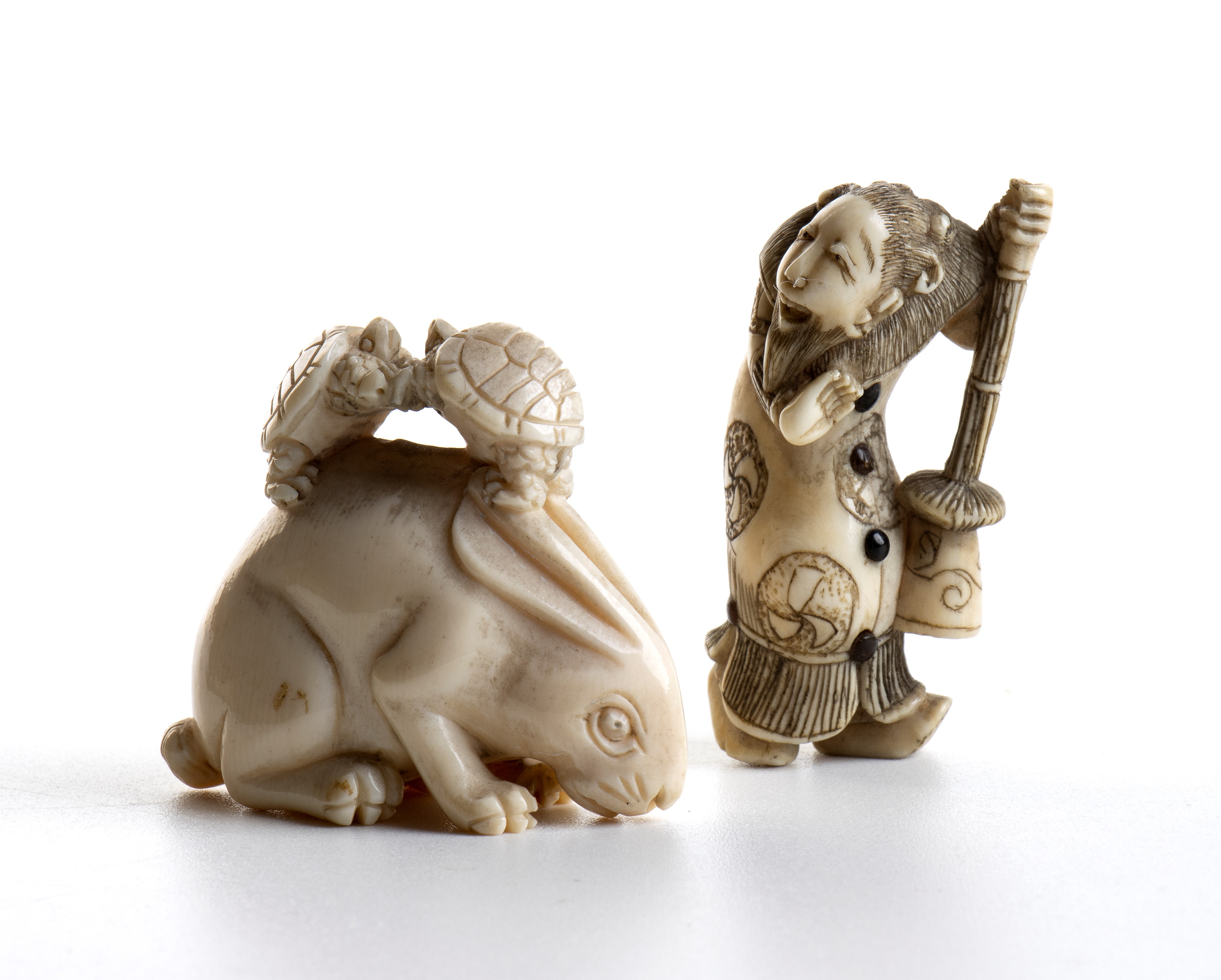 Coppia di netsuke in avorio marino scolpiti, raffigurazioni di tartarughe, coniglio e figura masc...