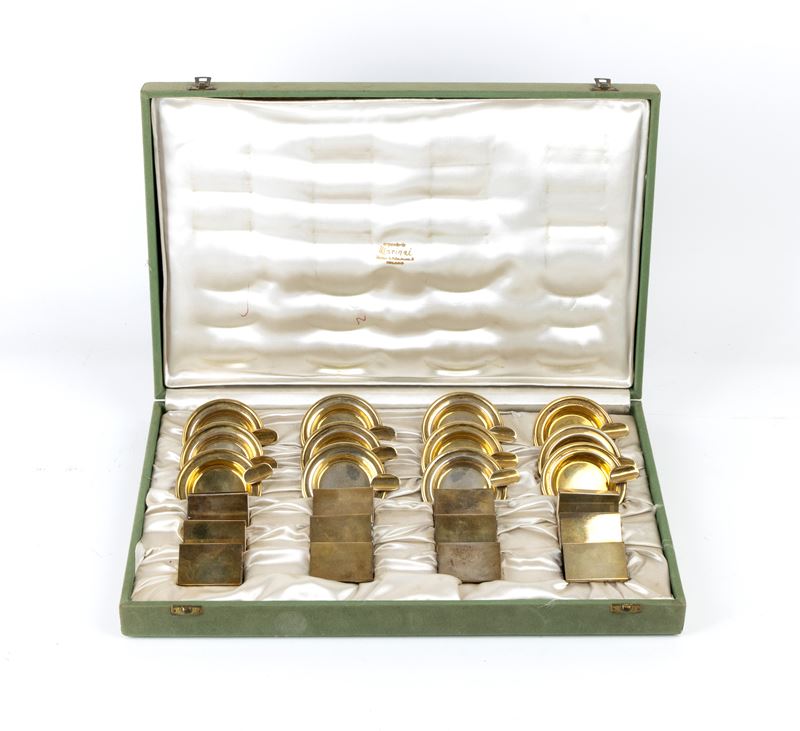 Italia metà XX secolo, Scatola con 12 portafiammiferi e 12 posacenere in argento dorato 800/1000