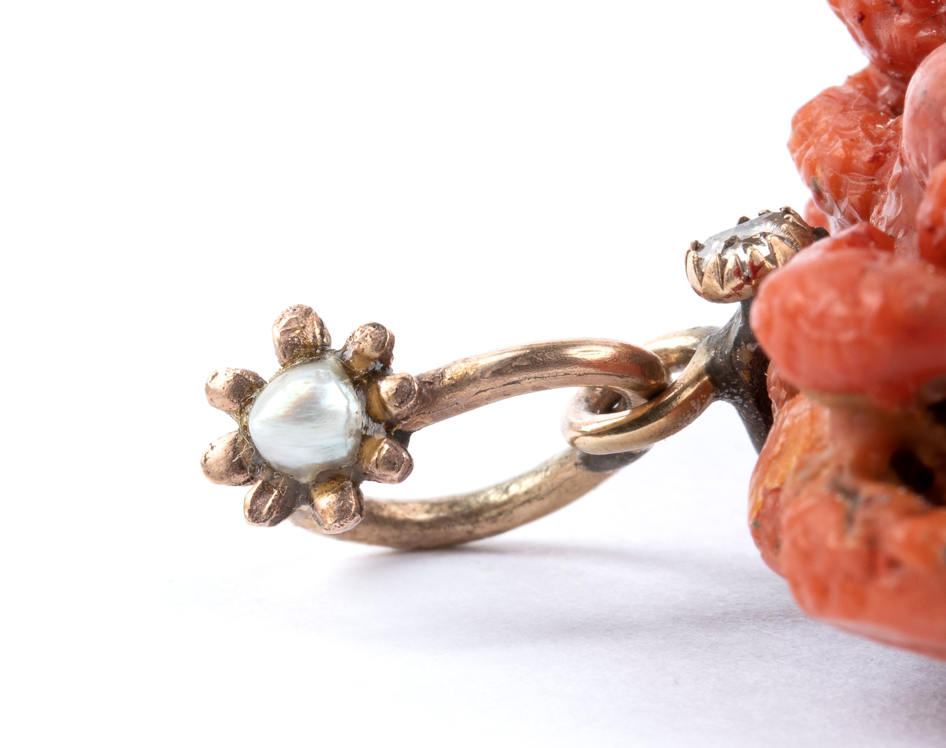 Pendente con corallo a testa di Medusa, montatura in oro basso titolo con piccoli diamanti