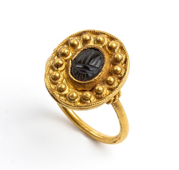 Archeological-style gold ring with engraved stone