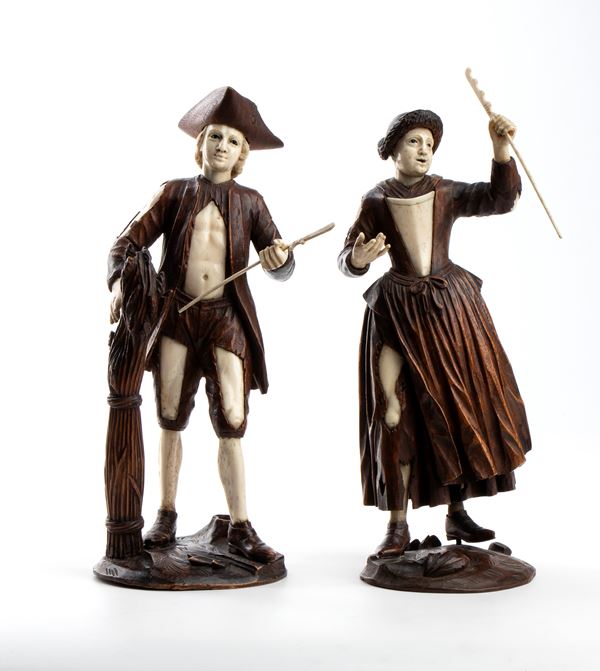 A pair of wood and bone carvings 