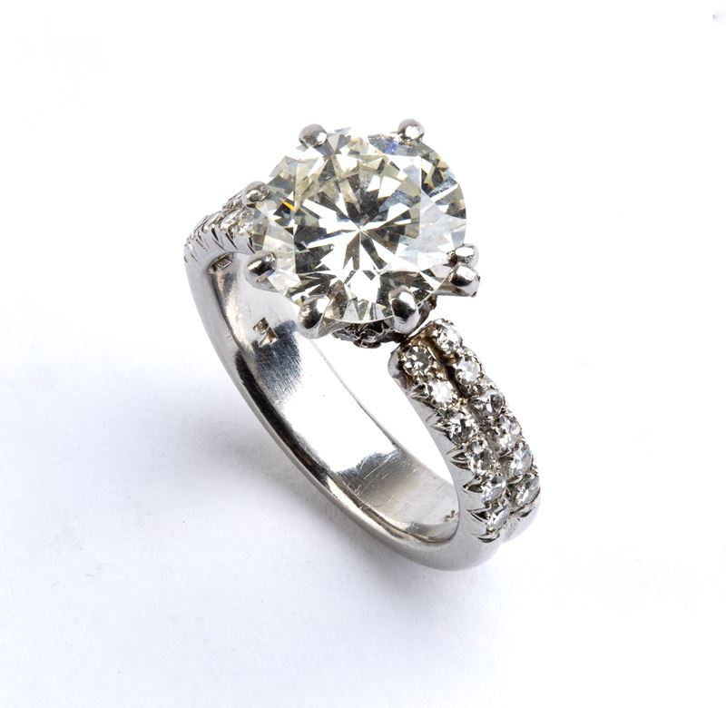 Anni ’80, Anello solitario in platino con diamante centrale e pavé di diamanti