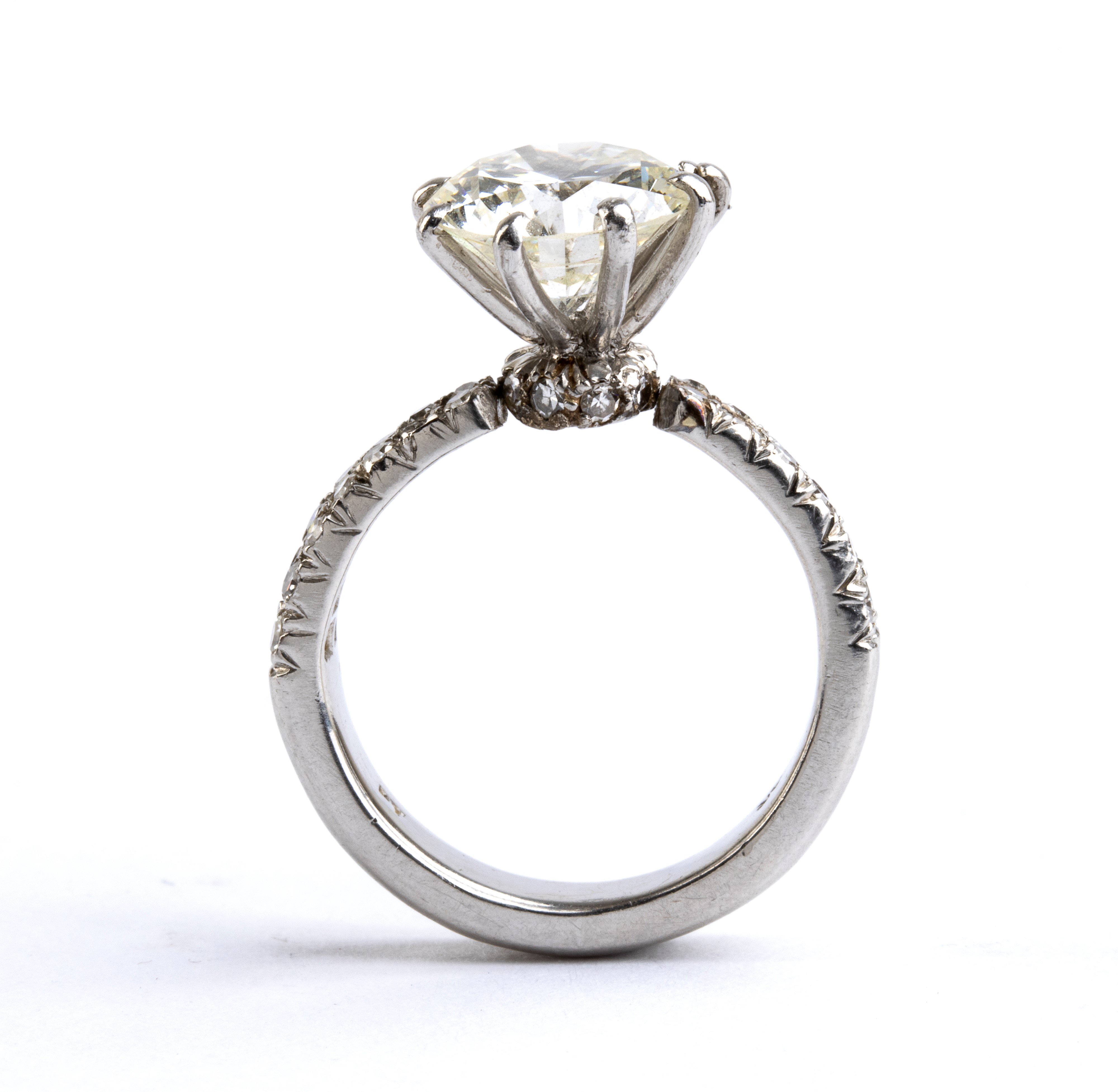 Anni ’80, Anello solitario in platino con diamante centrale e pavé di diamanti
