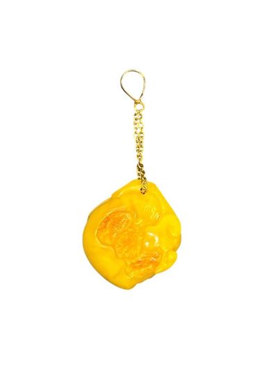 Pendente in oro e ambra, intaglio a forma di seme di pesco