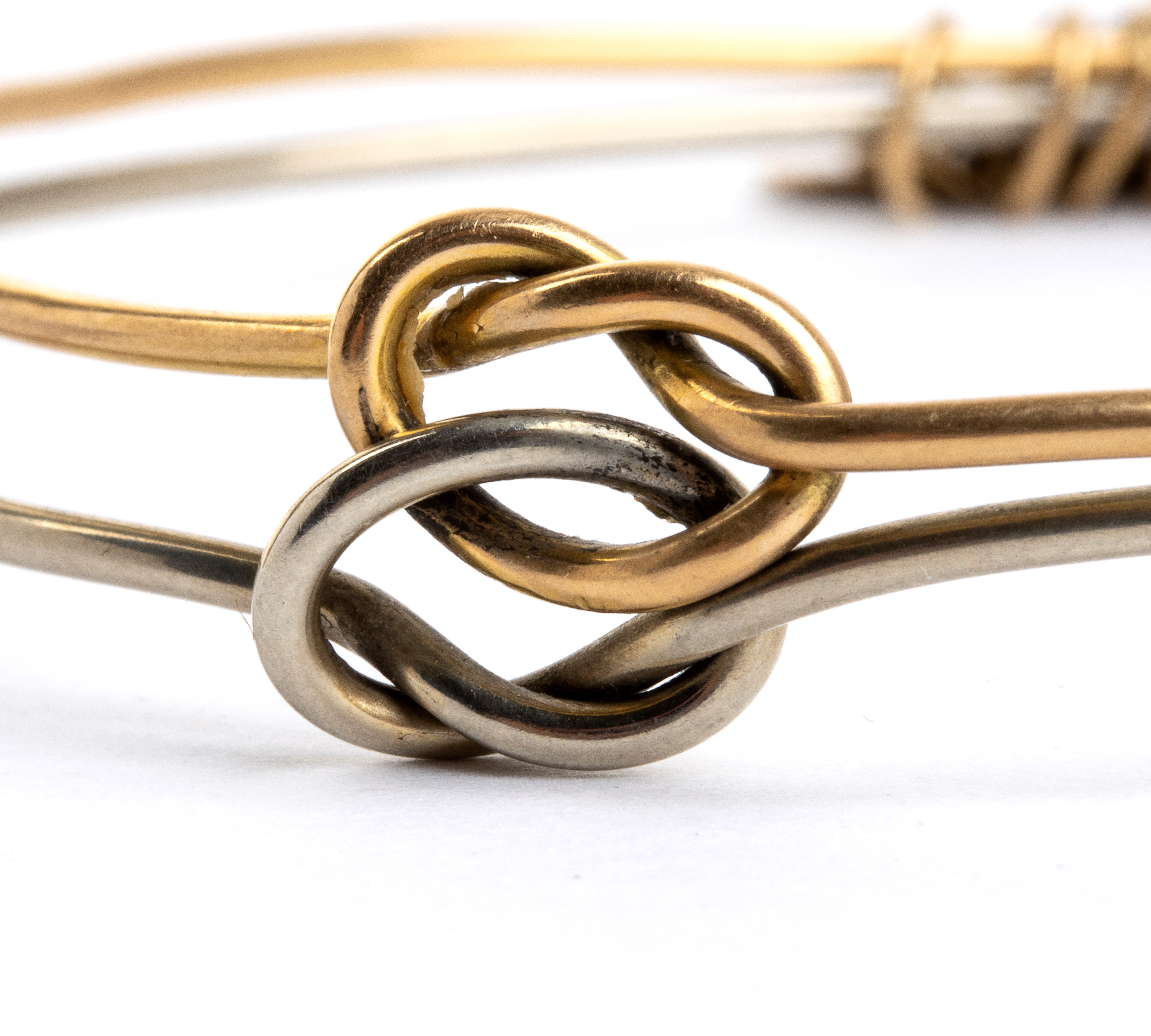 Bracciale rigido in oro bianco e oro giallo, doppio cerchio con pendenti a forma di medagliette
