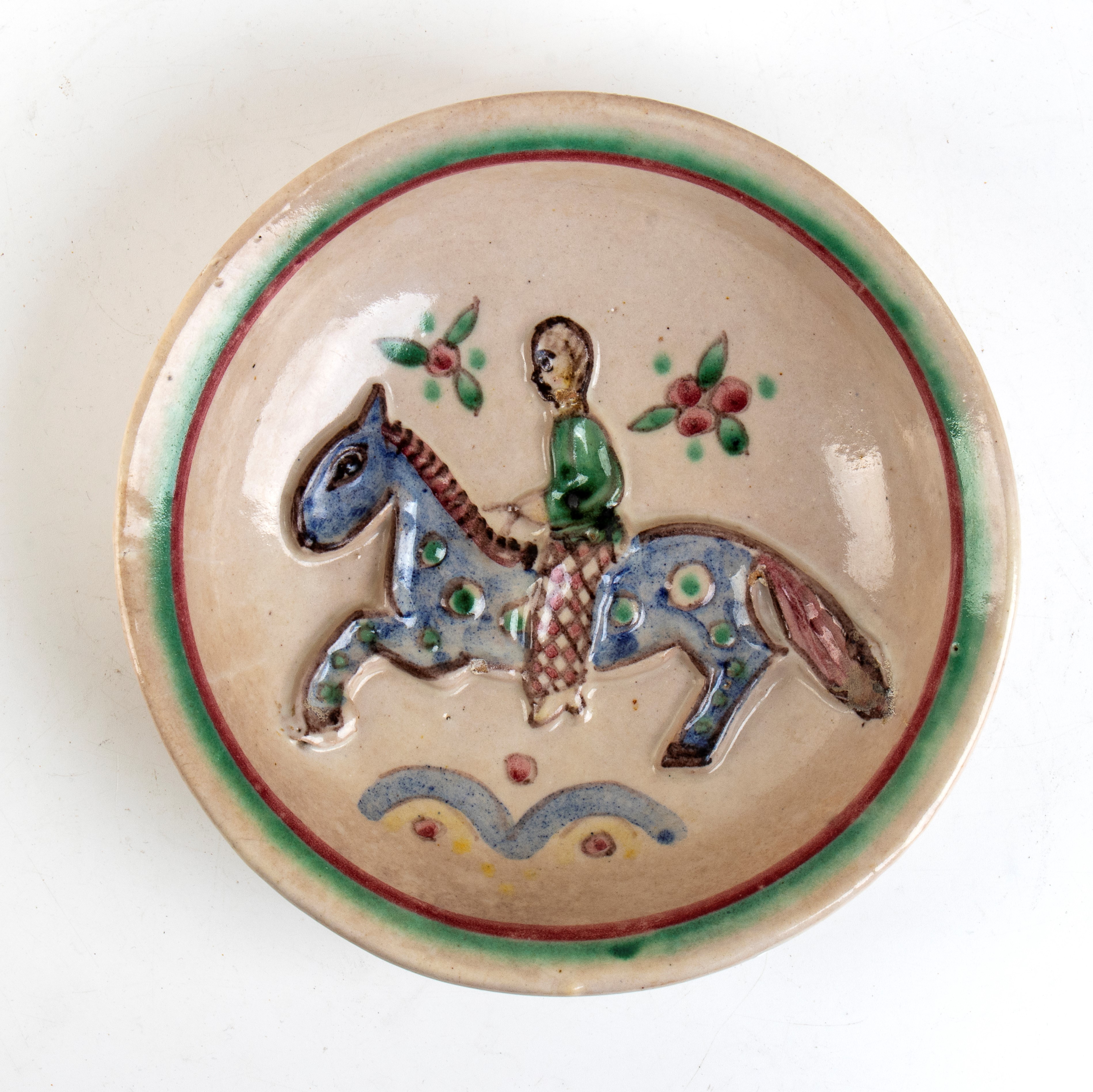 Piatto circolare con decorazione a rilievo di uomo a cavallo