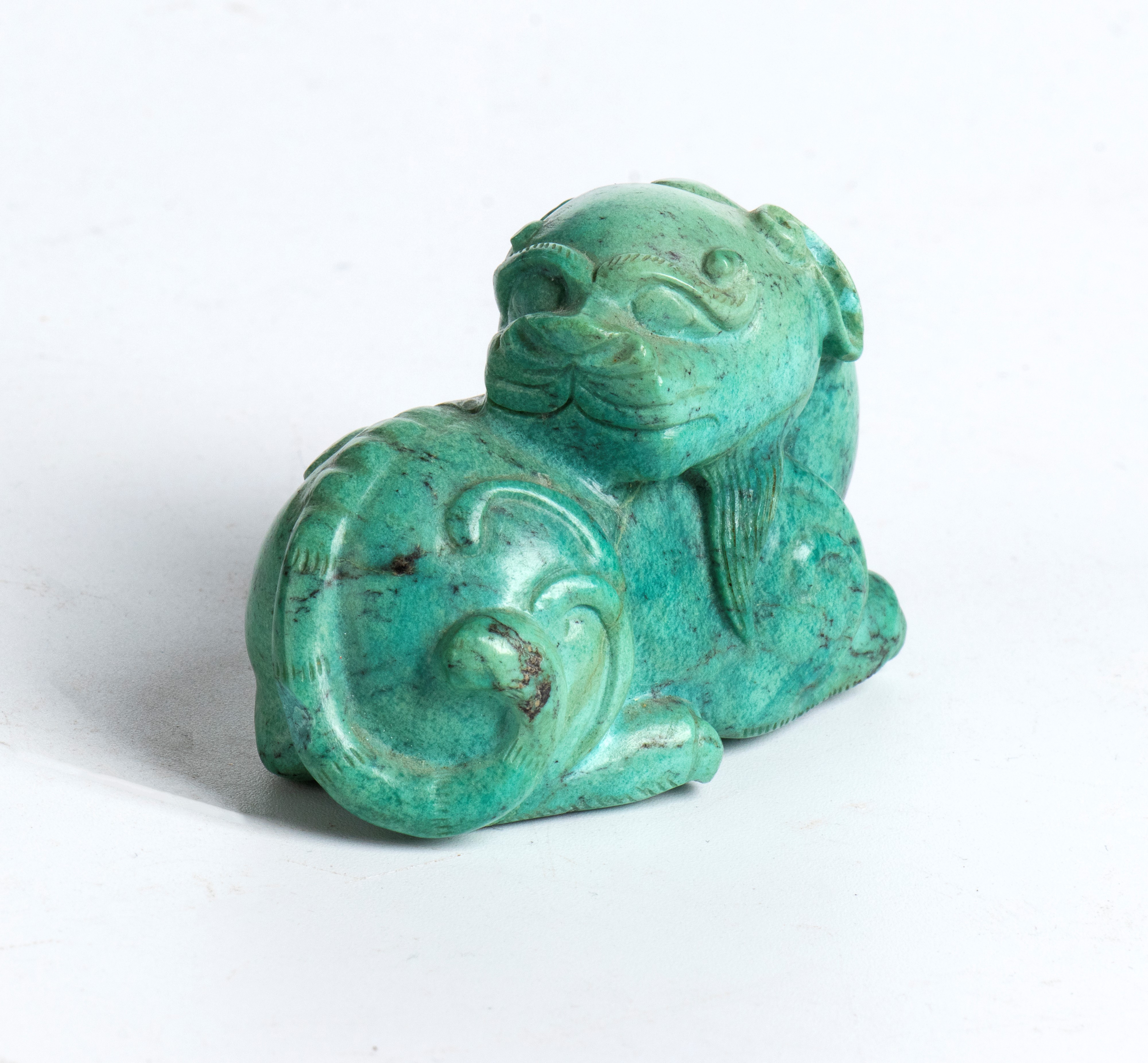 Figura in turchese scolpita in forma di leone accovacciato
