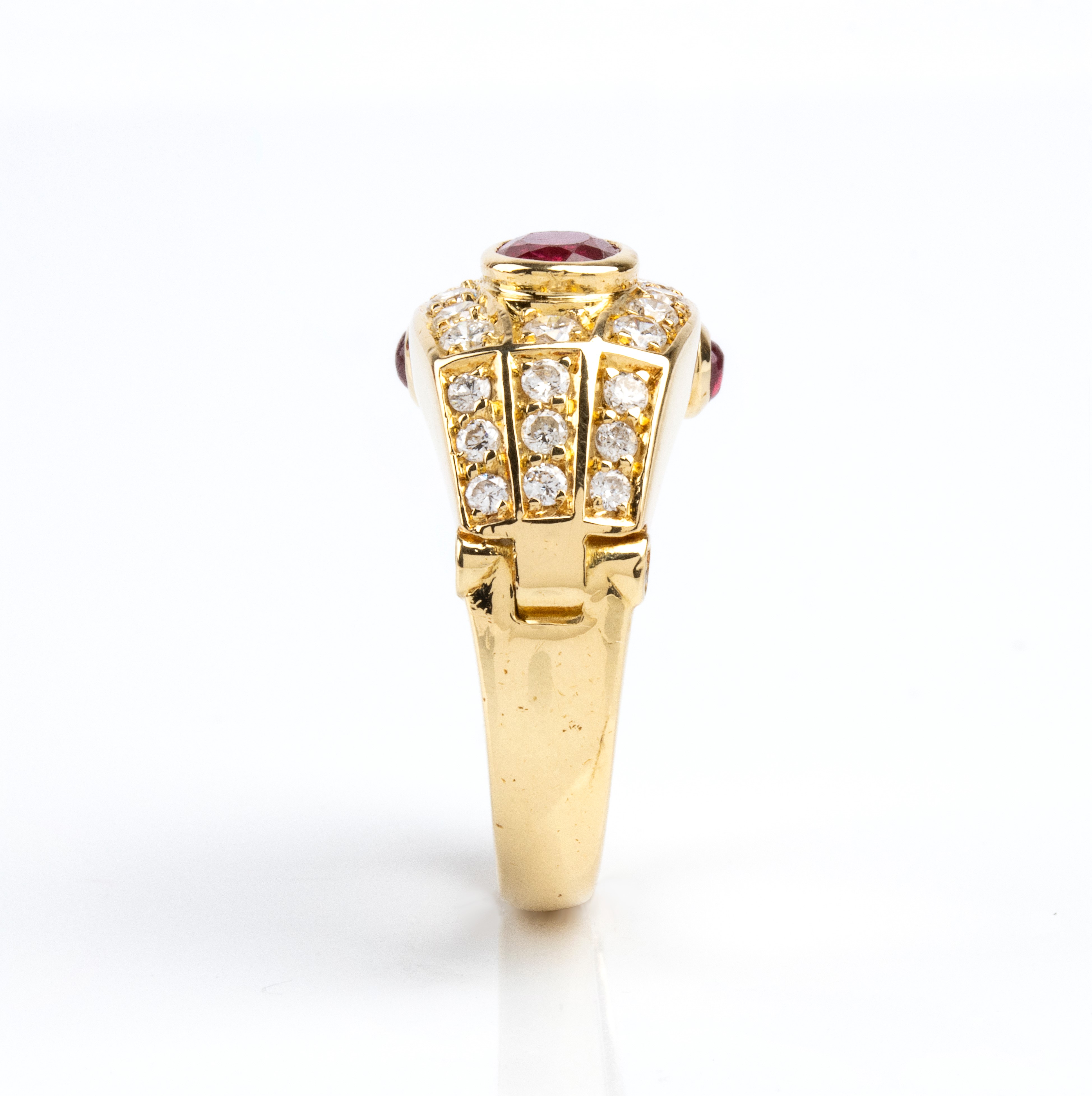 Anello a fascia in oro 18k con rubino ovale, diamanti e coppia di rubini cabochon