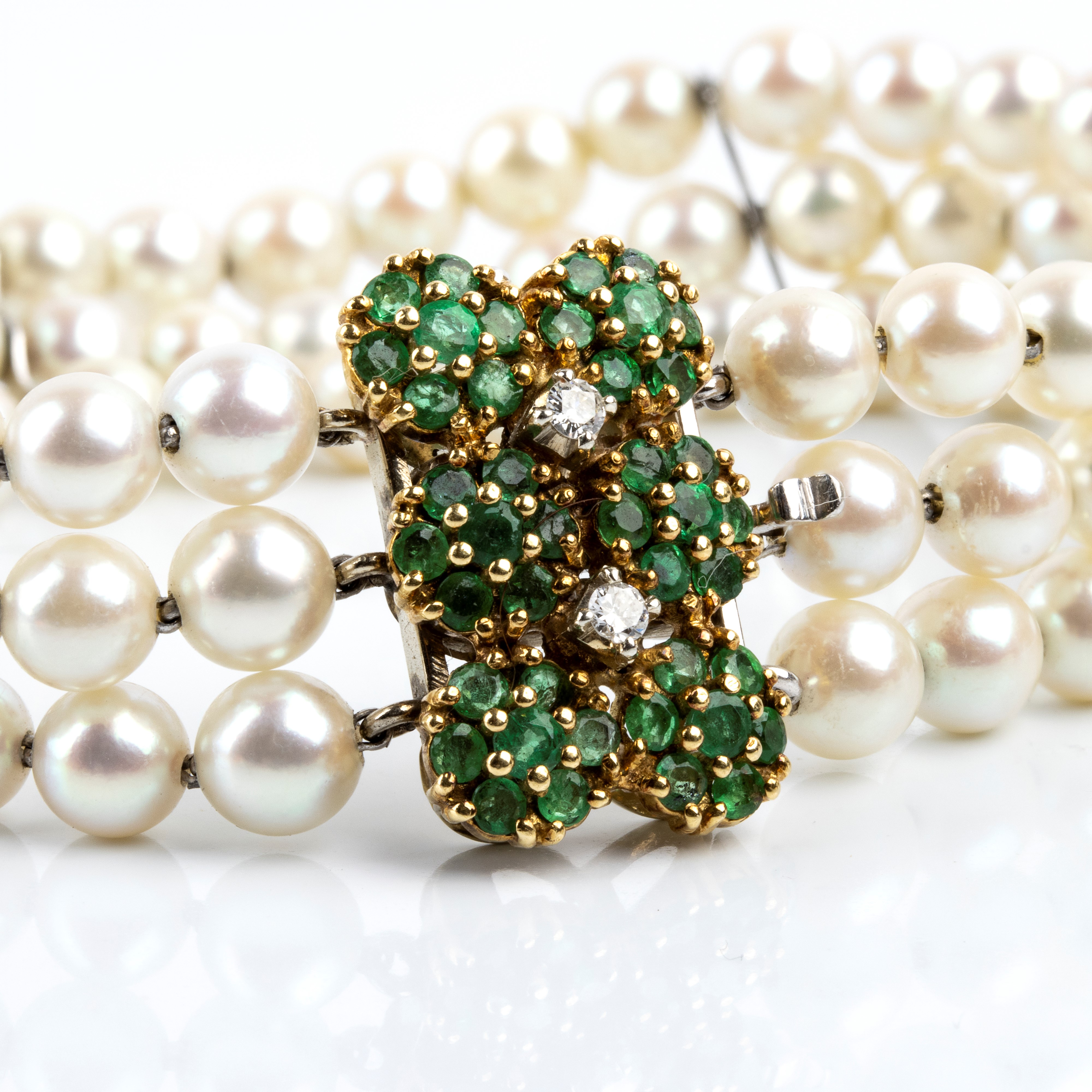 Bracciale a tre fili di perle coltivate con motivo a fiori, in oro 18k con smeraldi e diamanti