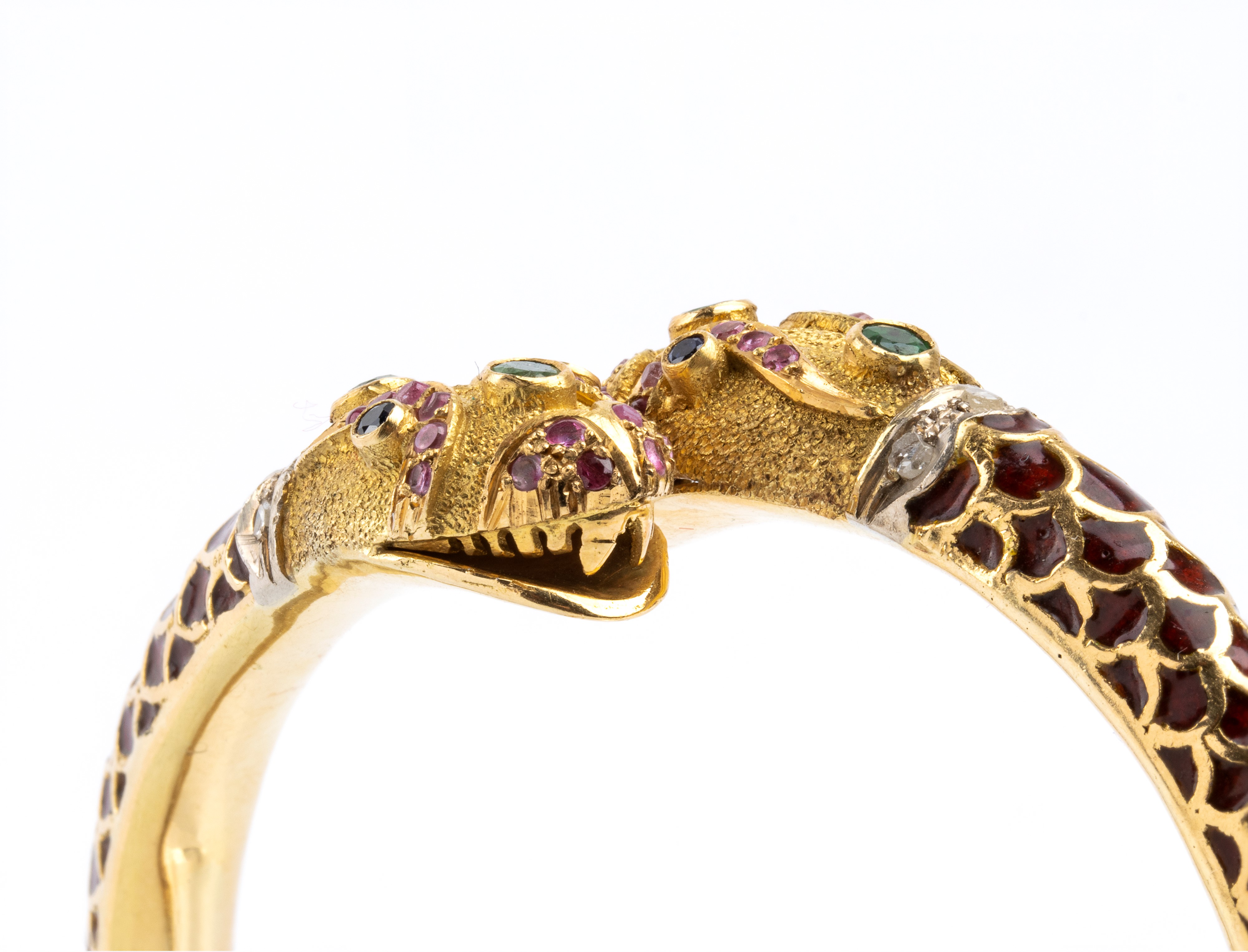 Bracciale rigido in oro 18k con due teste di serpente intrecciate, smalti e pietre colorate (anni...