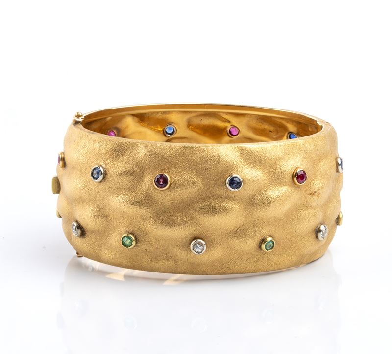 Bracciale a fascia rigida in oro giallo 18k, rubini, zaffiri, smeraldi e diamanti, anni ’80