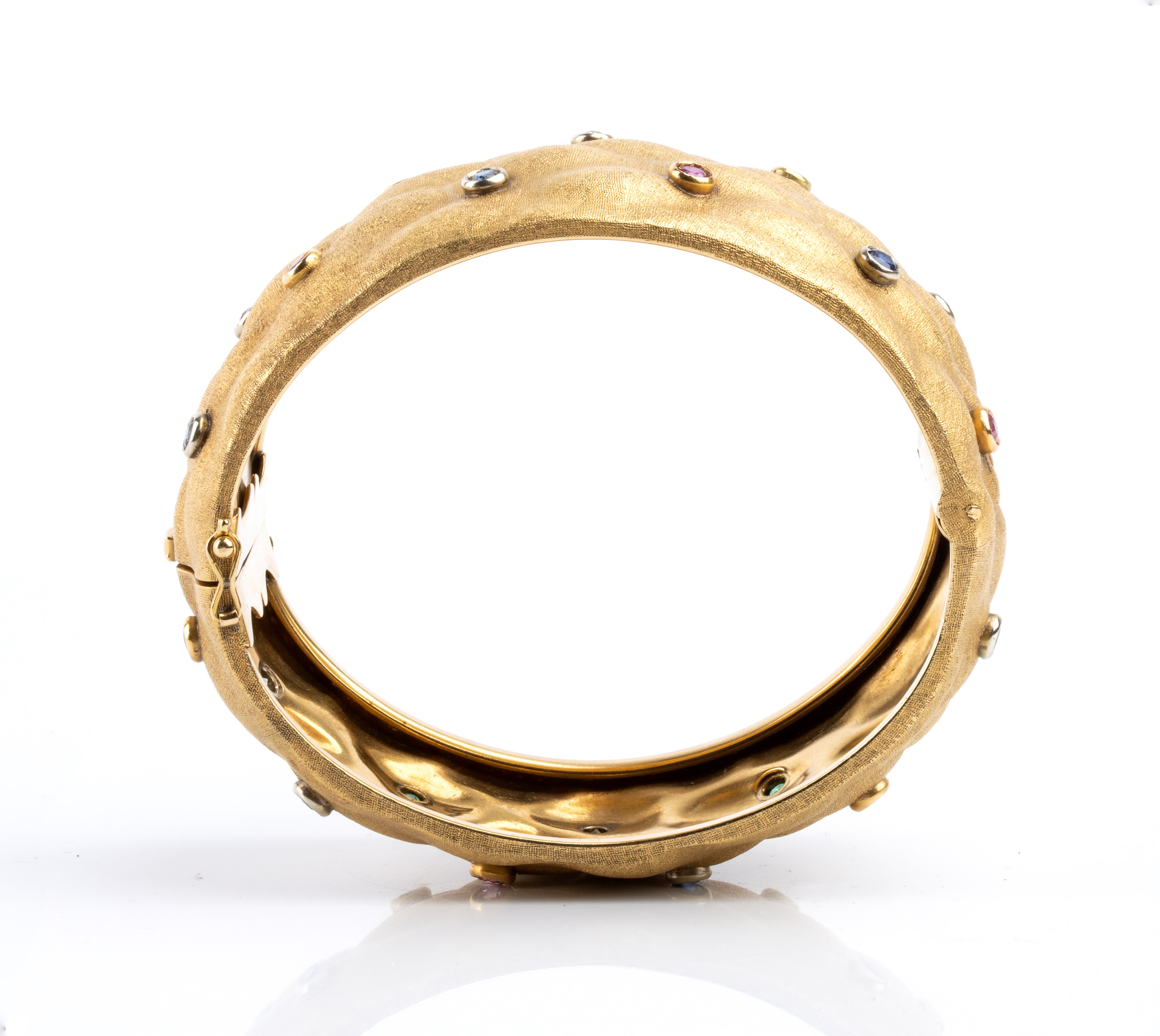 Bracciale a fascia rigida in oro giallo 18k, rubini, zaffiri, smeraldi e diamanti, anni ’80