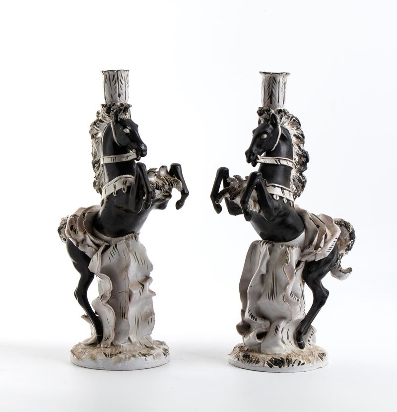 Due candelabri a forma di cavallo rampante