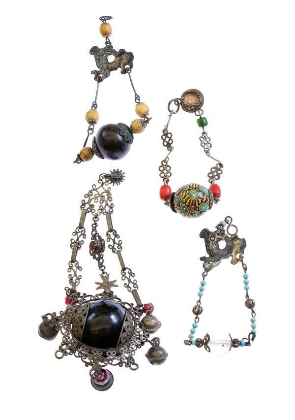 Four amulets made of silver, wood and glass paste