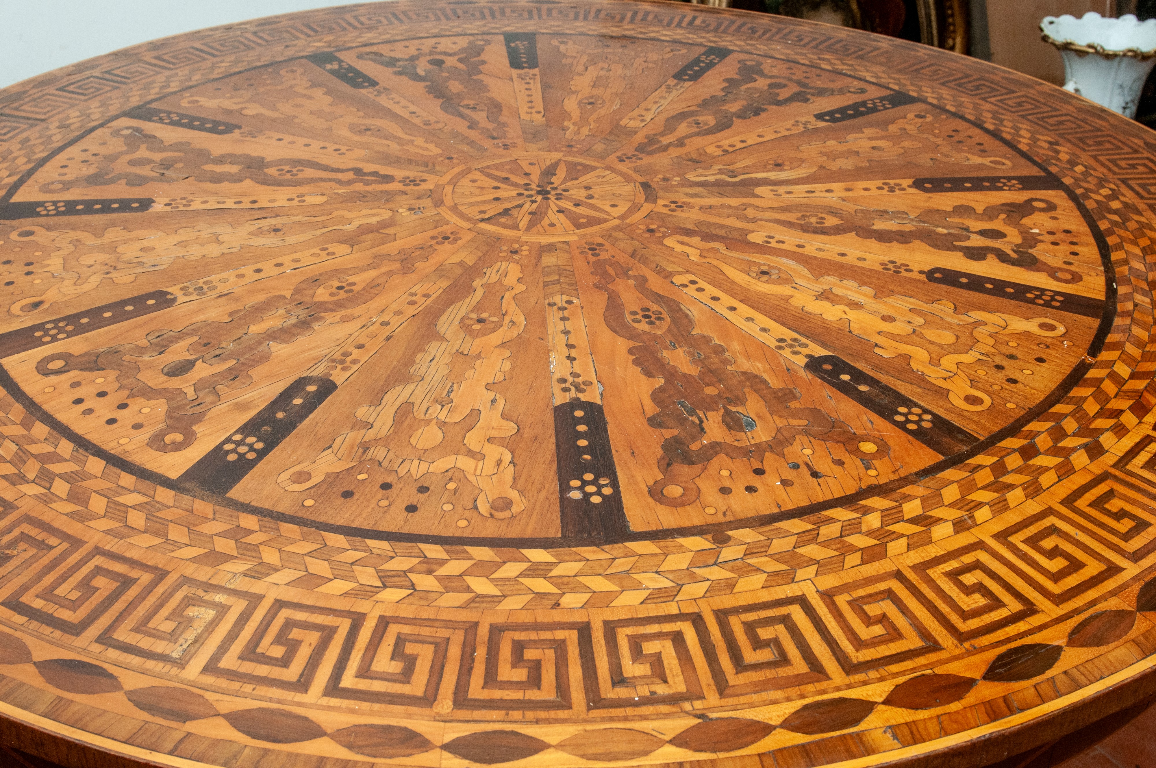 Tavolo tondo in legno di noce con piano a tarsie geometriche e base a tre piedi torniti (XIX/XX s...