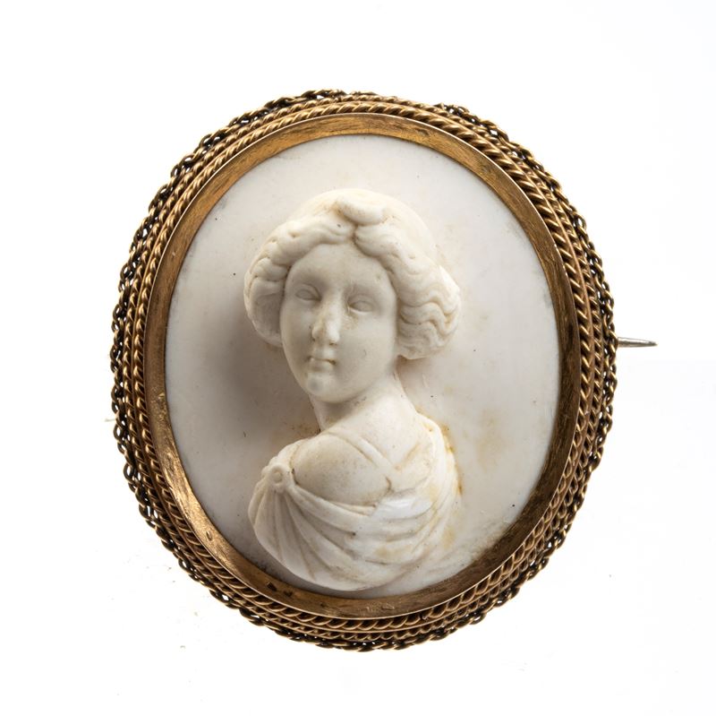 Spilla ottocentesca in oro giallo con cameo in pietra lavica bianca raffigurante un busto femmini...