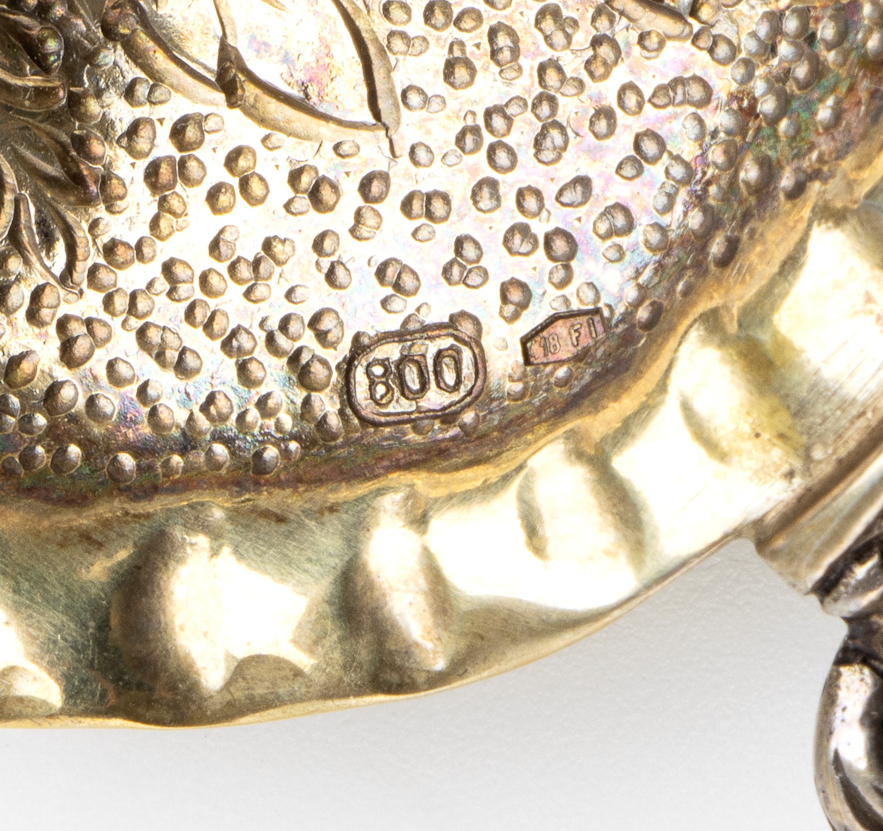 Italia, coppia di piattini e cucchiaio in argento 800/1000, decorazione a rilievo e traforatura (...