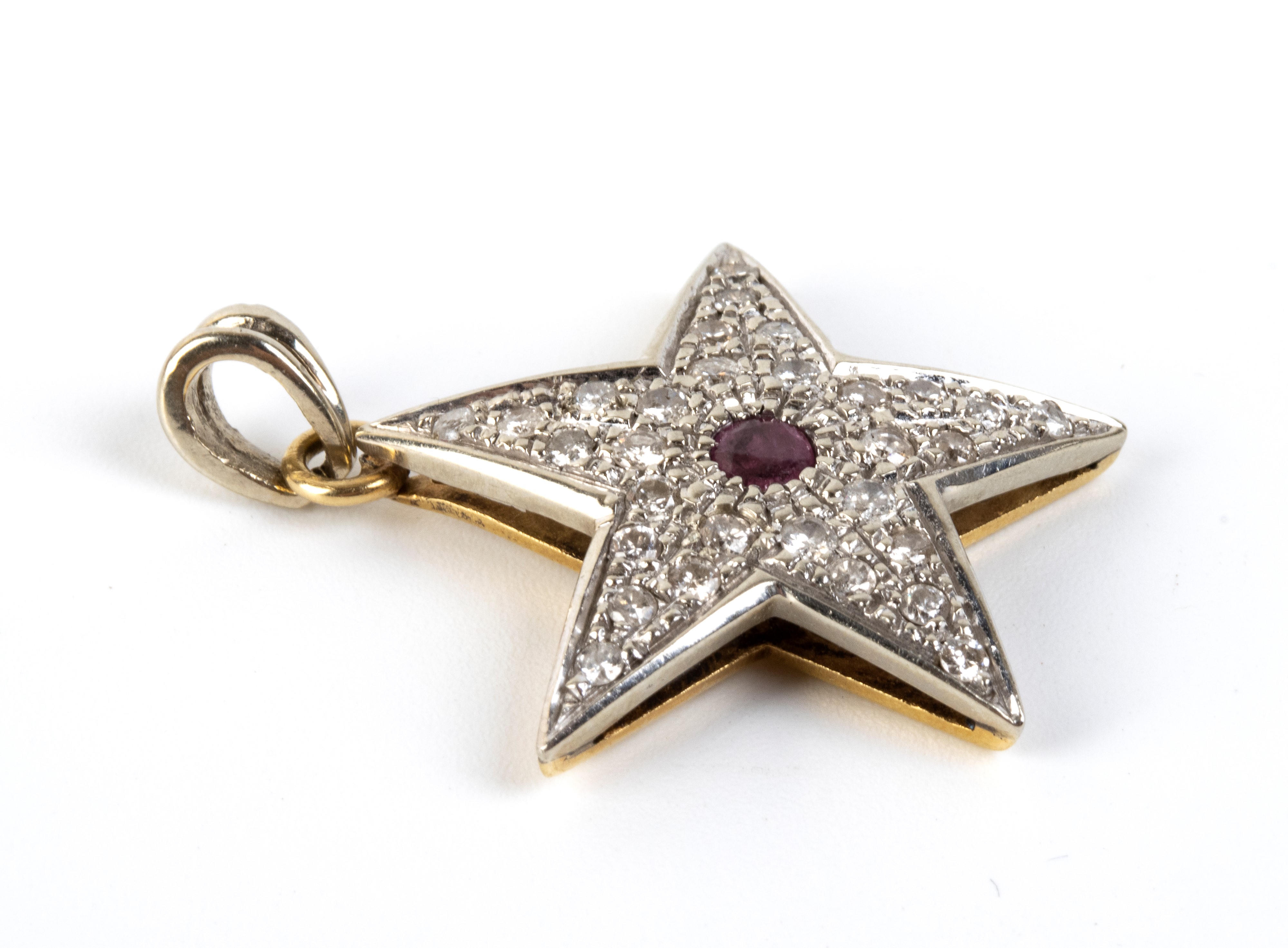 Pendente a stella in oro con rubino centrale e diamanti in pavé
