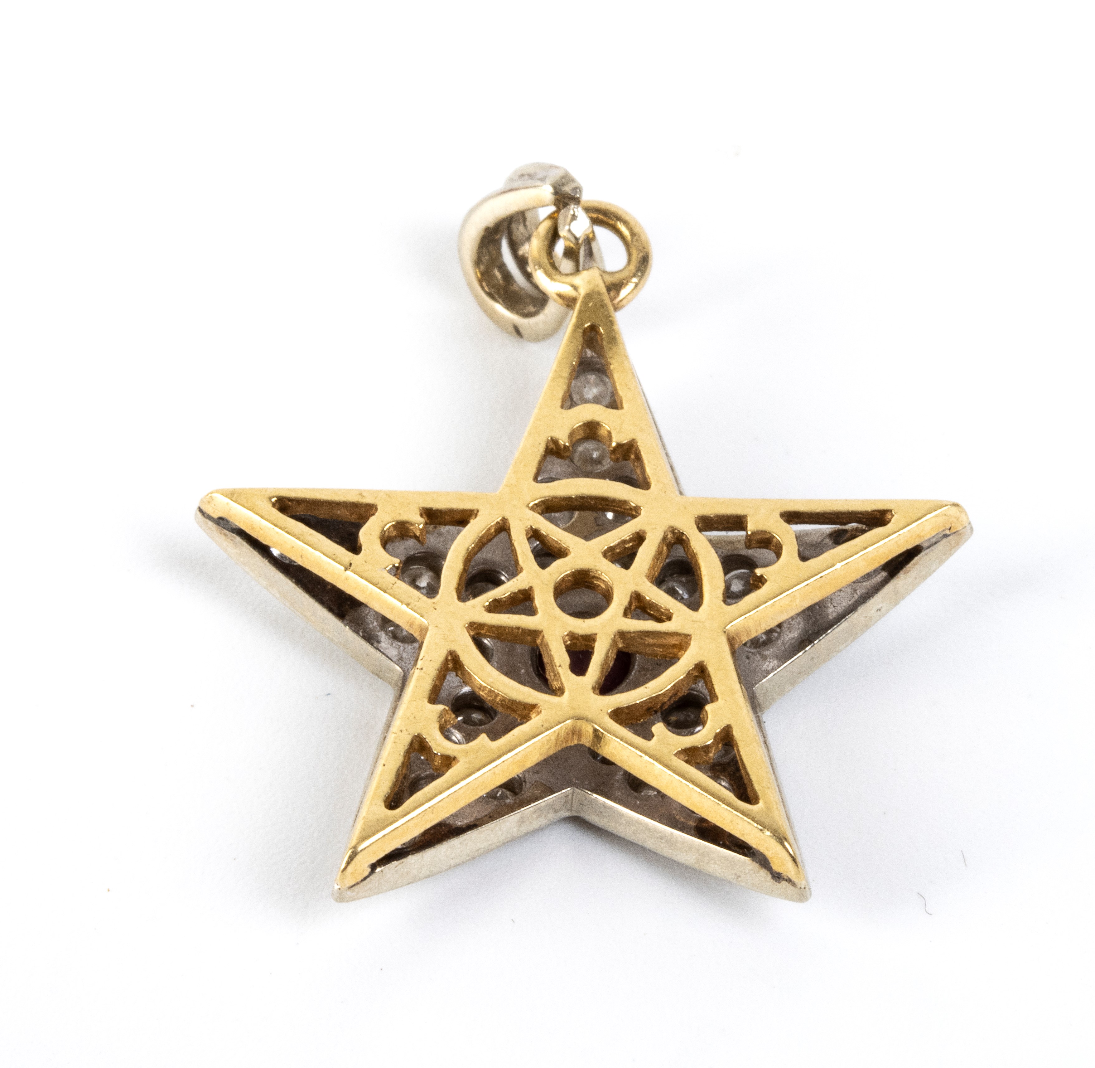 Pendente a stella in oro con rubino centrale e diamanti in pavé