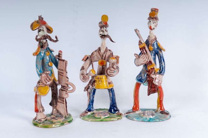 Lotto di tre figure militari stilizzate in ceramica policroma: