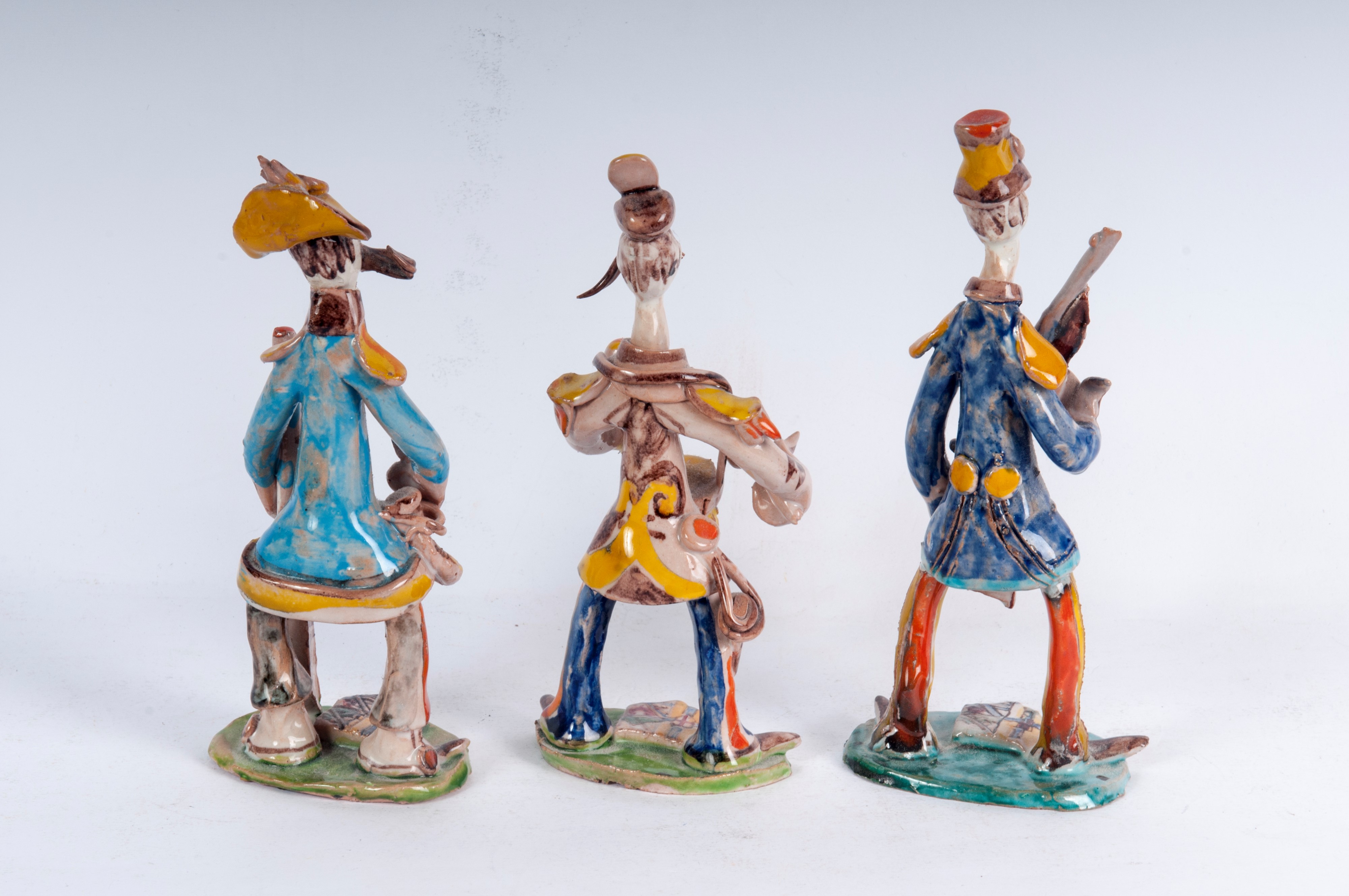 Lotto di tre figure militari stilizzate in ceramica policroma: