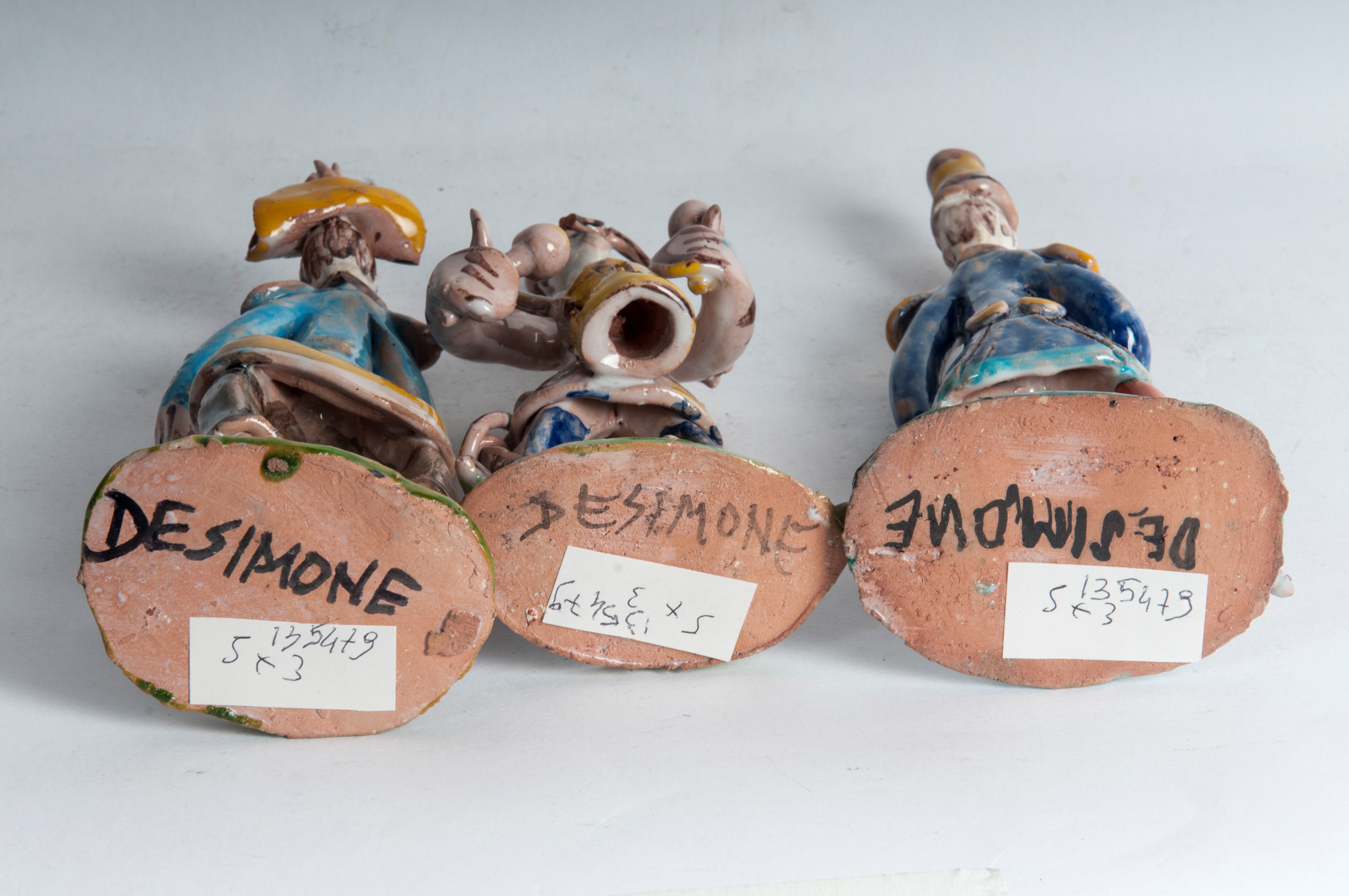 Lotto di tre figure militari stilizzate in ceramica policroma: