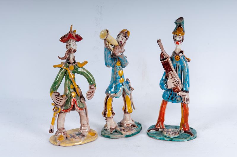 Lotto di tre figure militari stilizzati in ceramica policroma: