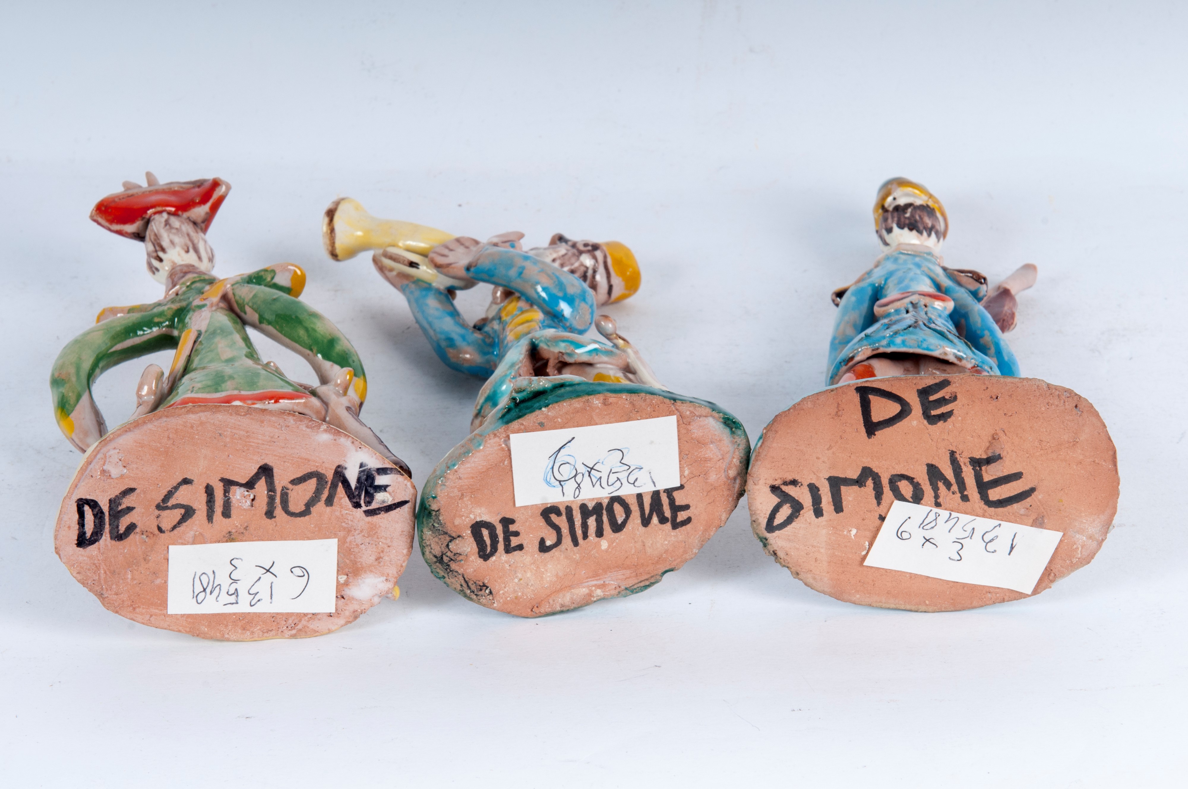 Lotto di tre figure militari stilizzati in ceramica policroma: