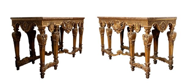 A pair of large carved and gilded wooden consoles with Louis XVI-style marble tops