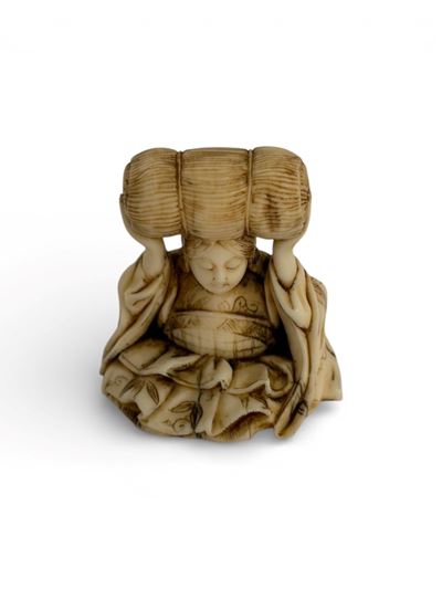 Giappone (periodo Meiji), Netsuke in avorio a soggetto di elefante con figura seduta e balla di r...