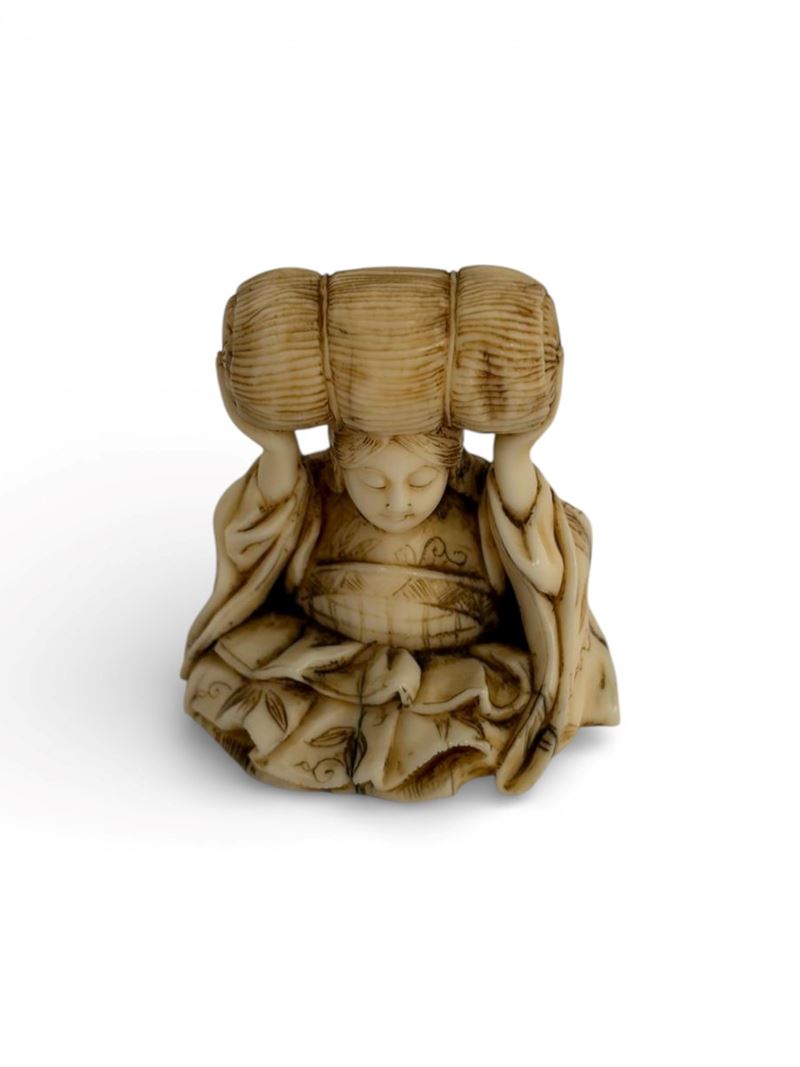 Giappone (periodo Meiji), Netsuke in avorio a soggetto di elefante con figura seduta e balla di r...