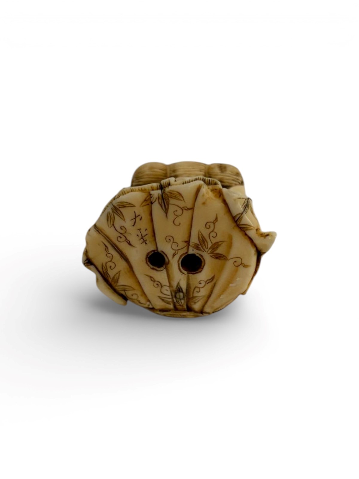 Giappone (periodo Meiji), Netsuke in avorio a soggetto di elefante con figura seduta e balla di r...