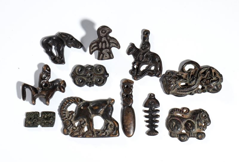 Gruppo di undici amuleti buddisti in bronzo legato, Cina, XX secolo