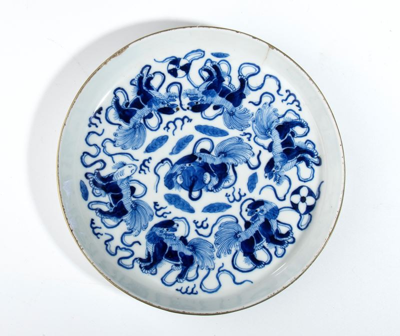 Piatto in porcellana bianca e blu con decorazione di cani pechinesi, Cina, dinastia Qing