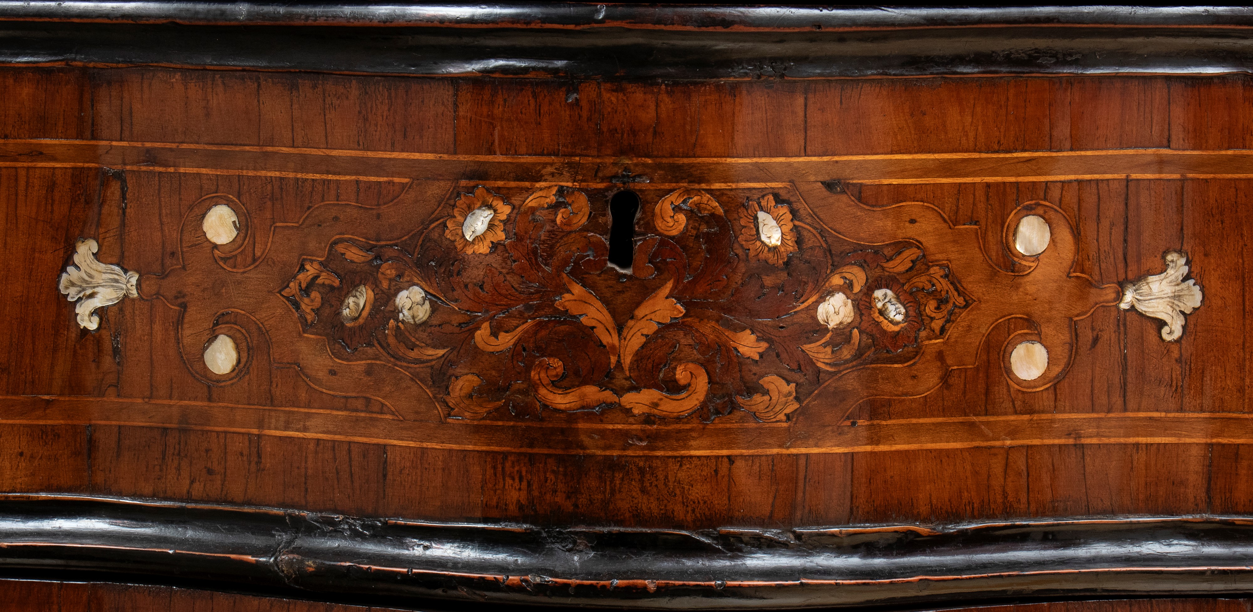 Comò mosso lastronato e intarsiato in osso