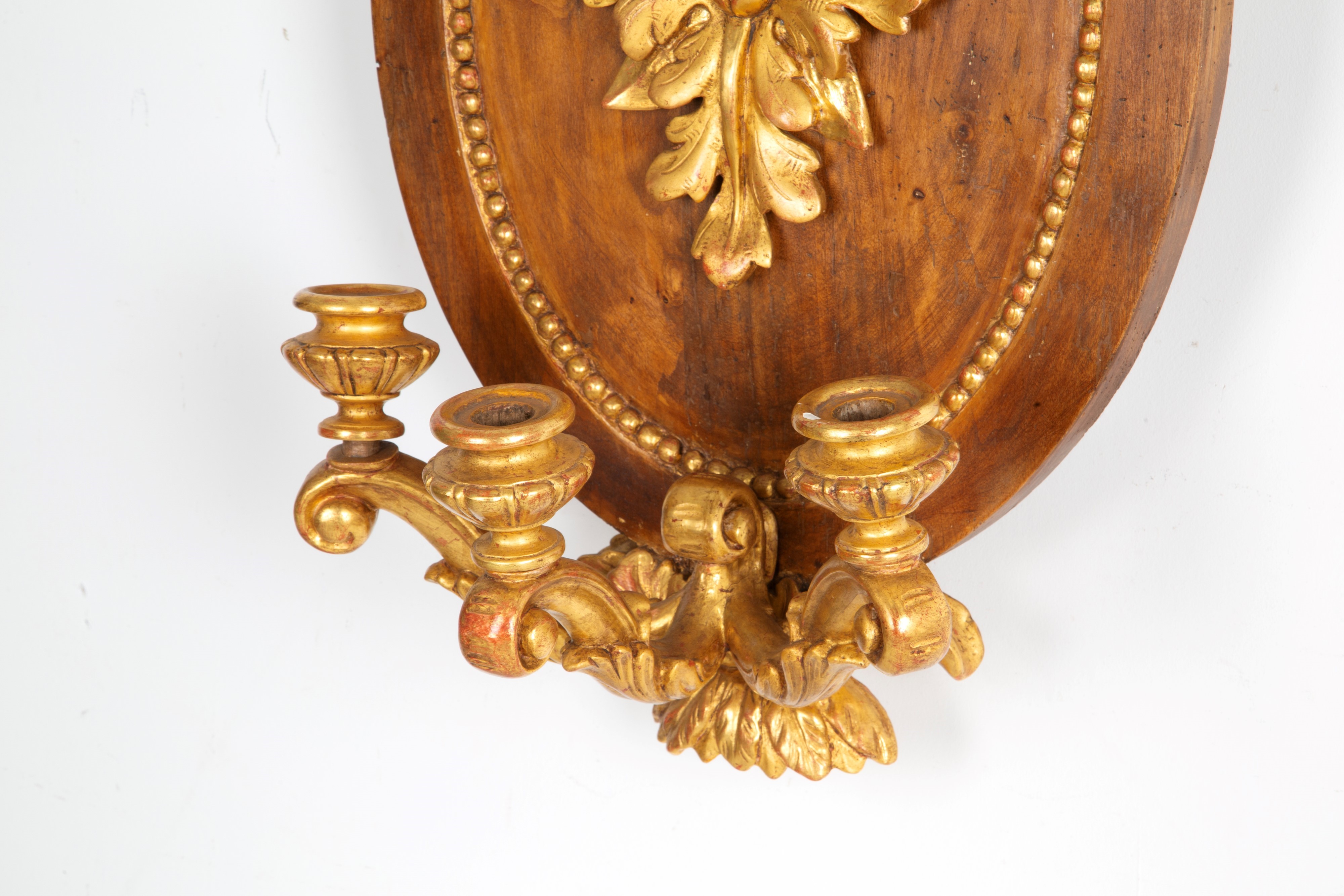 Coppia di applique a tre luci, legno scolpito e parzialmente dorato, XIX secolo
