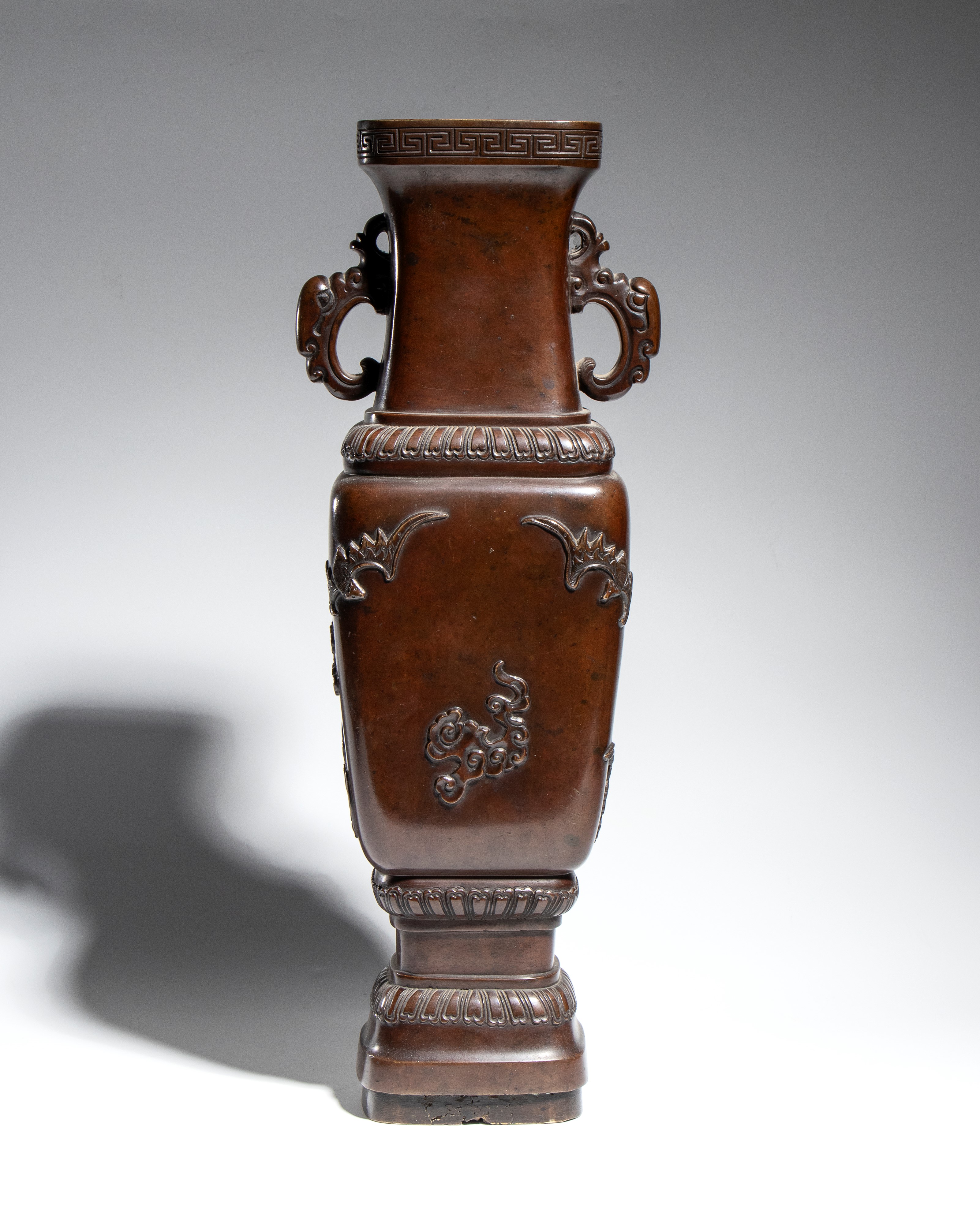 Giappone, Vaso in bronzo fuso a patina marrone scuro, corpo quadrato e manici zoomorfi (periodo M...