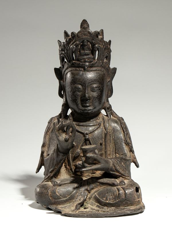 Bronze figure of a seated Bodhisattva wearing a headdress. In one hand, he holds a kasala, while the other performs a mudra gesture. China, Ming Dynasty, 15th-16th century