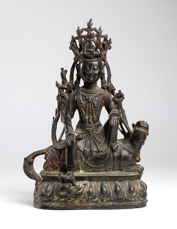 A bronze figure of a Bodhisattva, depicted seated on a mythical creature and a lotus-shaped base, wearing fine jewelry and a high crown. China, Ming Dynasty, 15th-16th century.