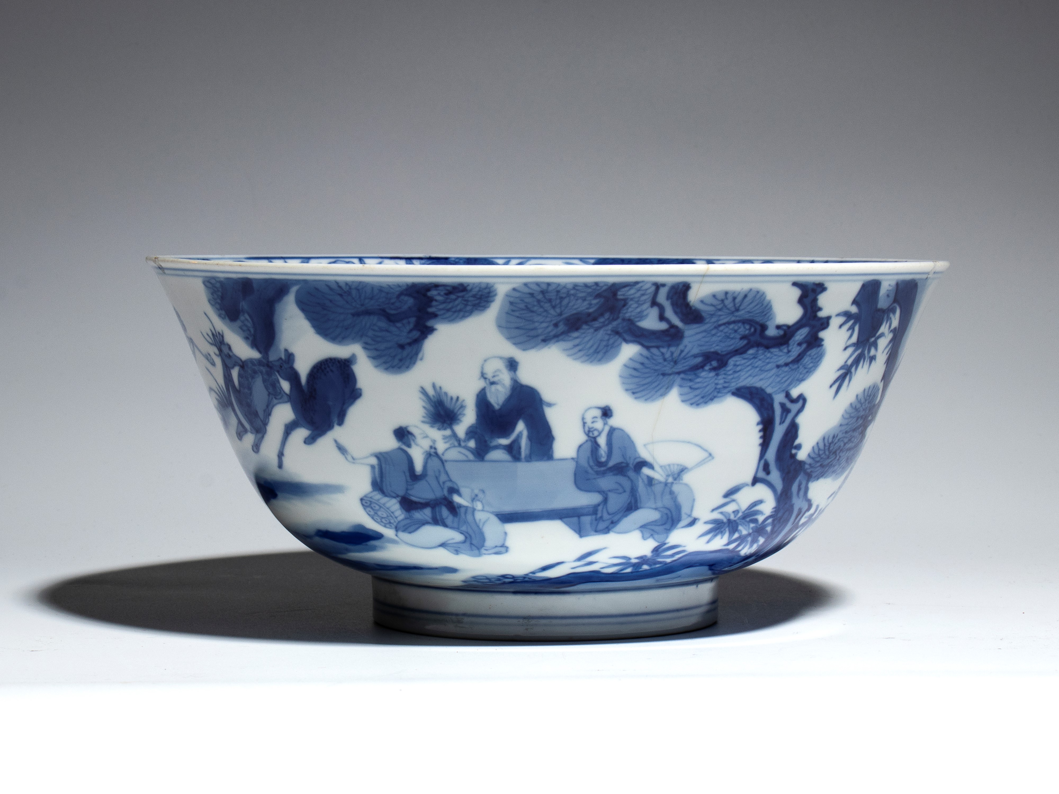 Cina, ciotola in porcellana bianca e blu con figure e decoro naturalistico, periodo di Transizion...