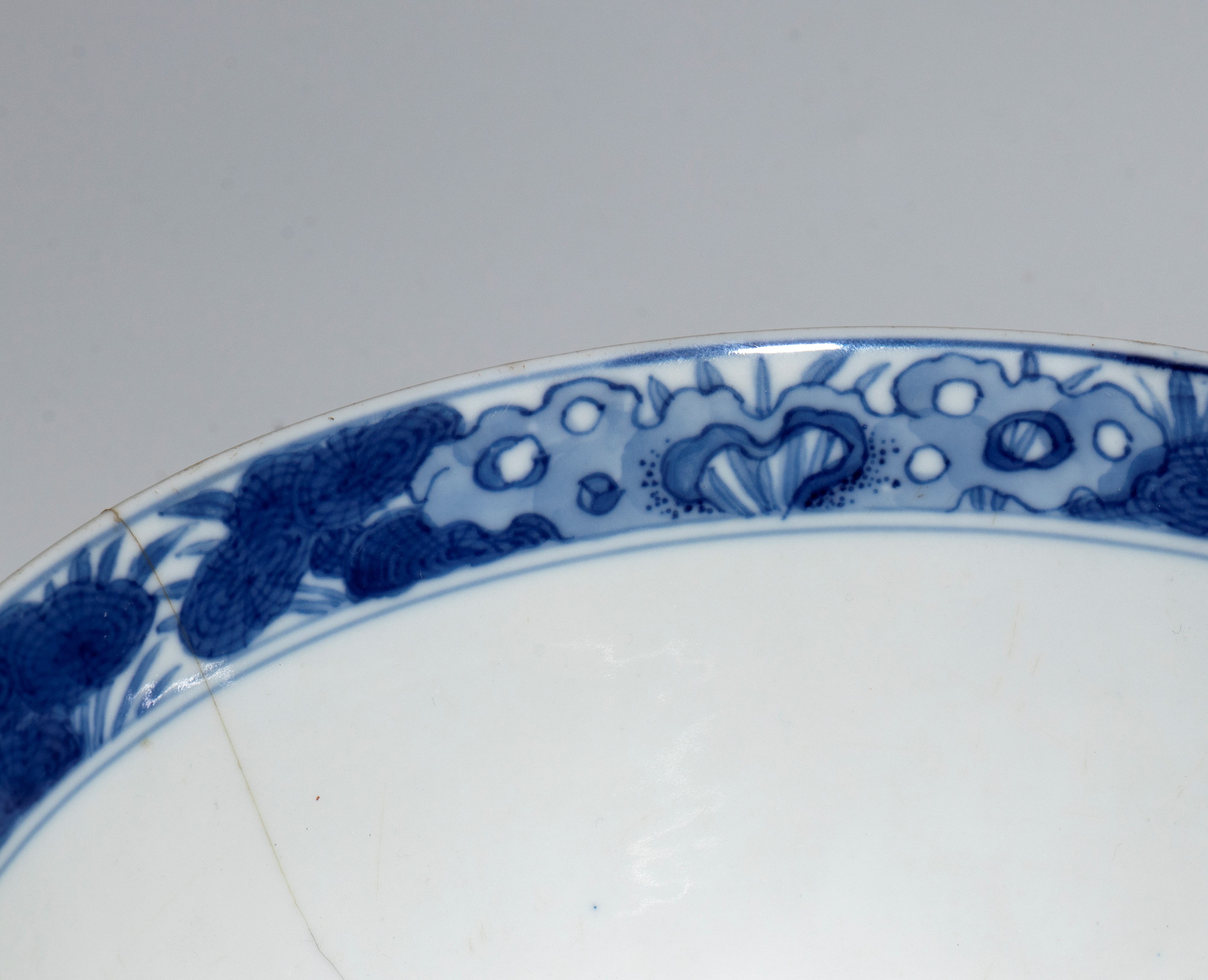 Cina, ciotola in porcellana bianca e blu con figure e decoro naturalistico, periodo di Transizion...