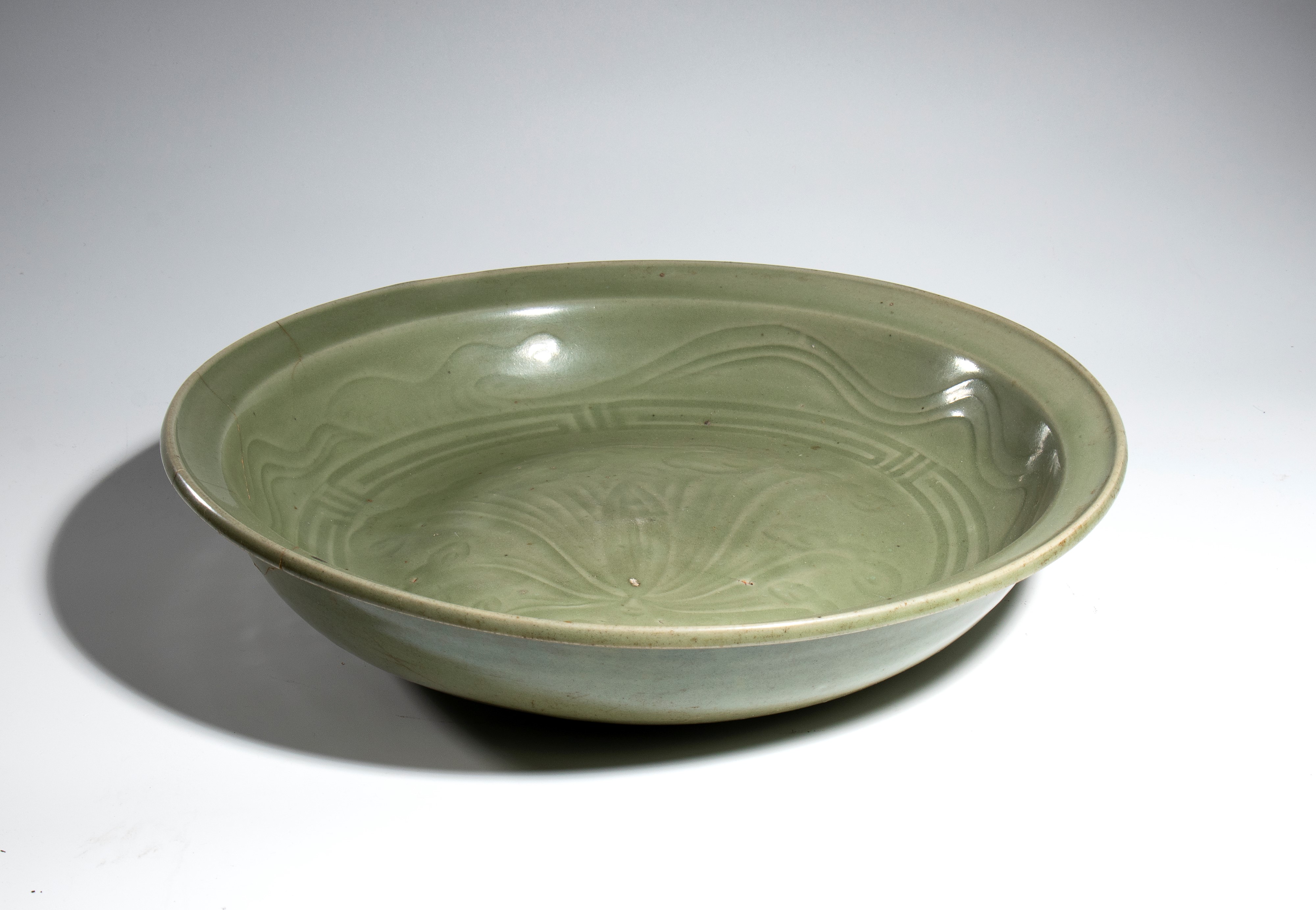Asia del Sud, Grande piatto profondo in porcellana celadon con decoro floreale e motivi geometric...