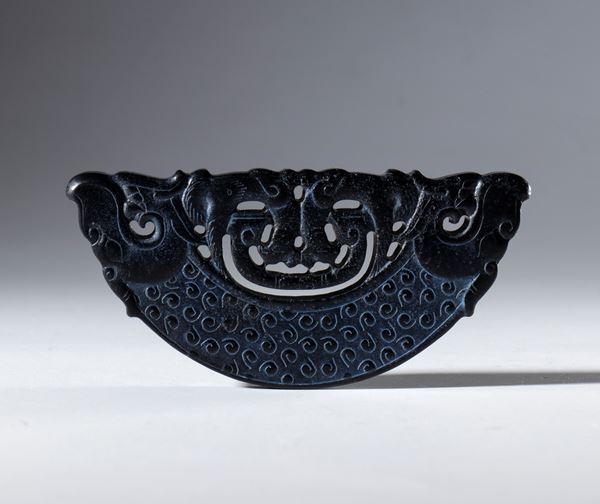 Ornamental half-disc. Engraved and pierced Hotan dark jade. Decorated with spiral motifs and stylized animal figures at the ends. China, 18th century