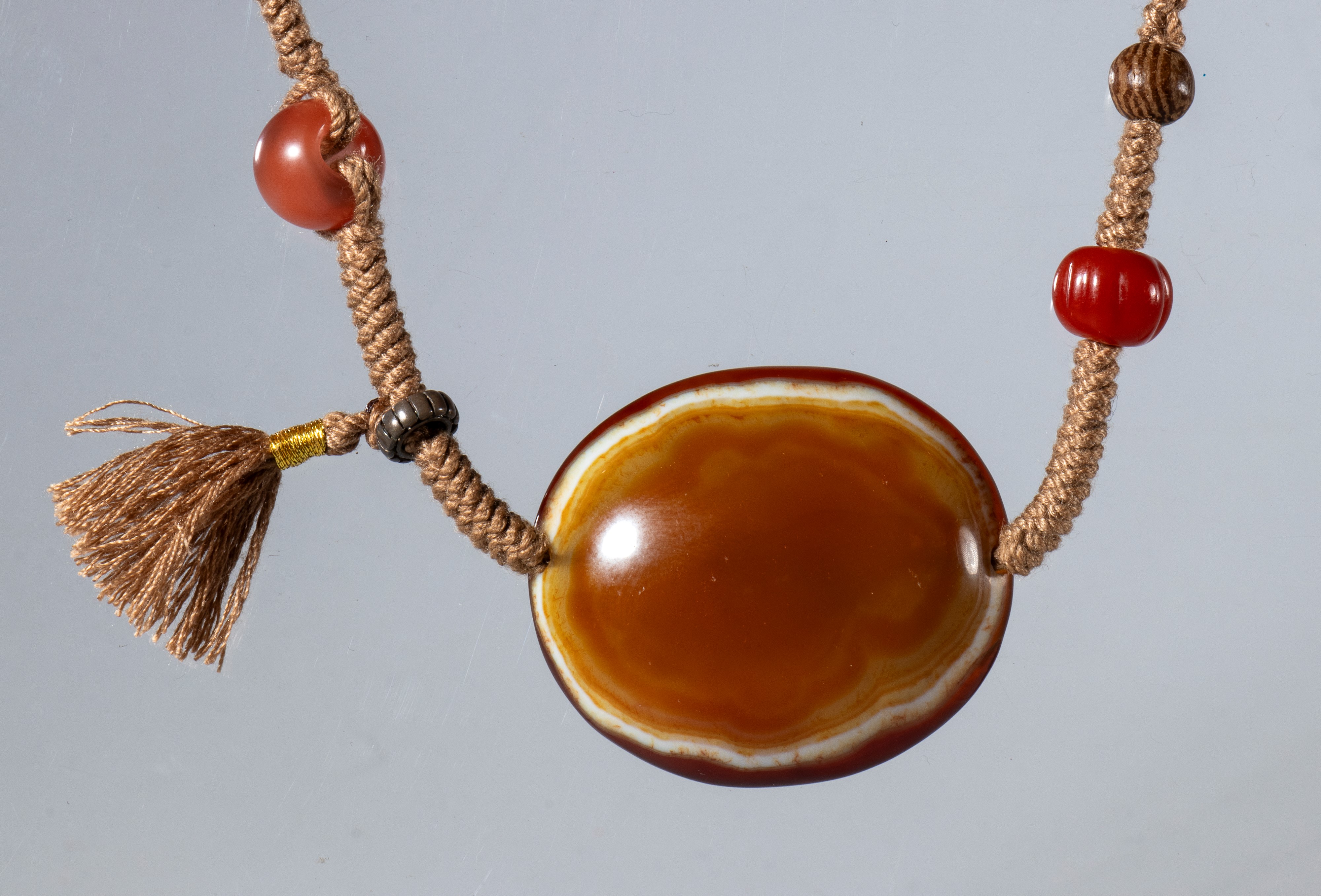 Lukmik, Collana con perla piatta e elementi in agata zonata, corniola, legno, osso e argento, Tib...